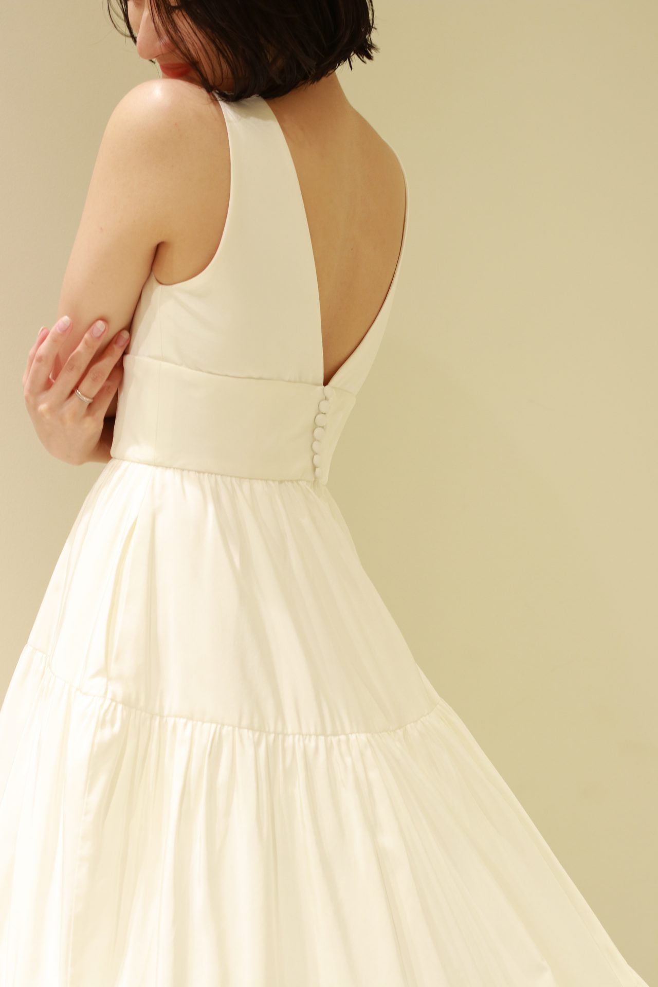 アメリカ発祥のドレスブランド、アムサーラの新作ドレスは、愛らしいくるみボタンがバックコンシャスな一着で、赤坂プリンスクラシックハウスのアットホームなお式におすすめです