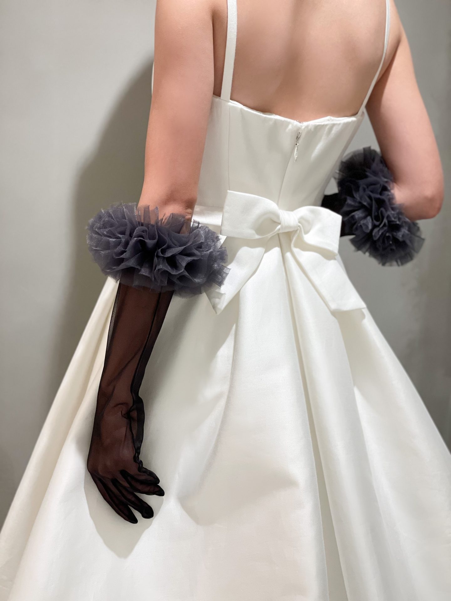 バックスタイルが美しいキャロリーナヘレラのウェディングドレスのコーディネートには黒のグローブを合わせて