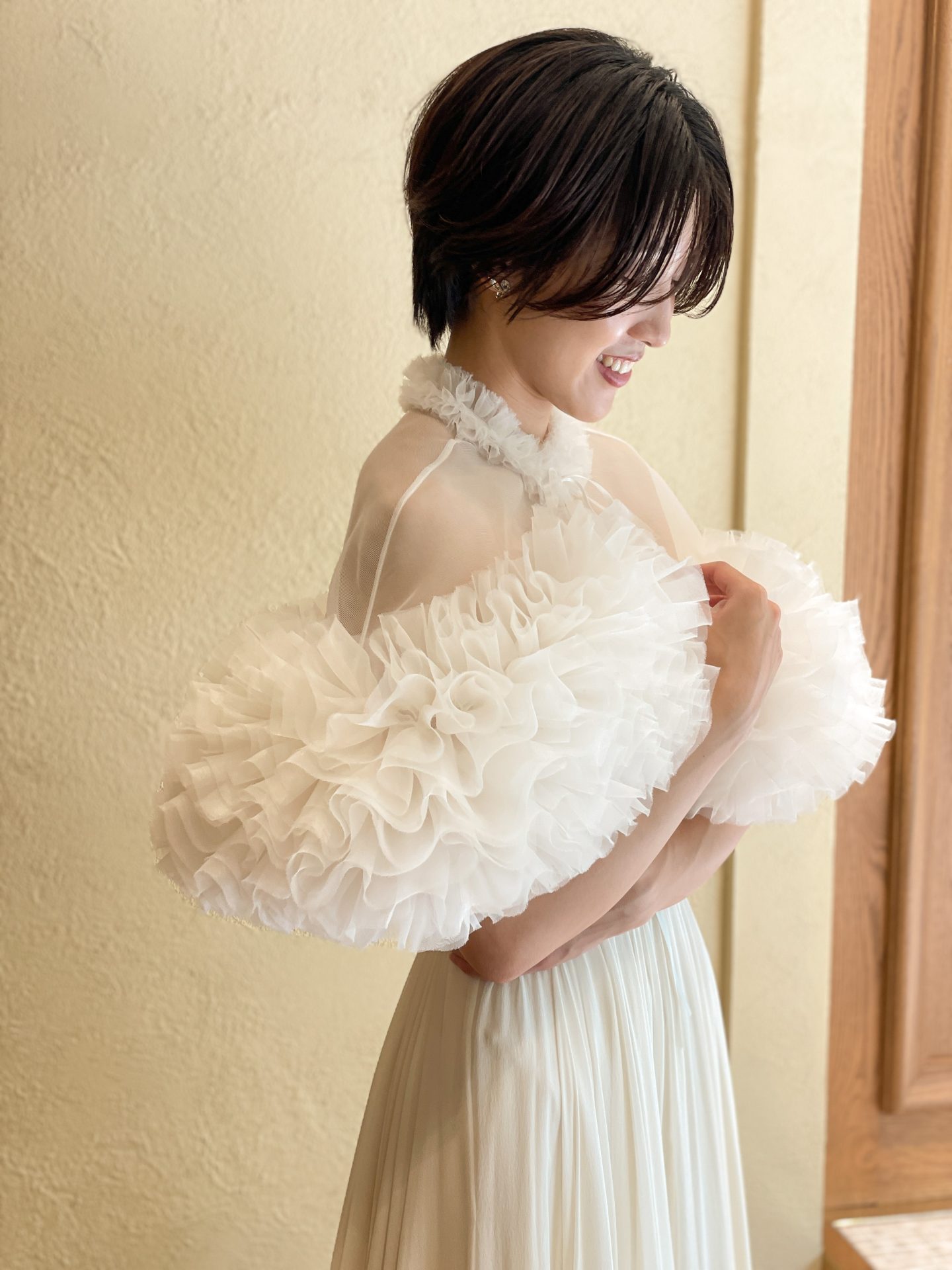 TOMO KOIZUMI for TREAT MAISONのウェディングケープはオーガンジーのラッフルが華やかでドレッシーな印象に