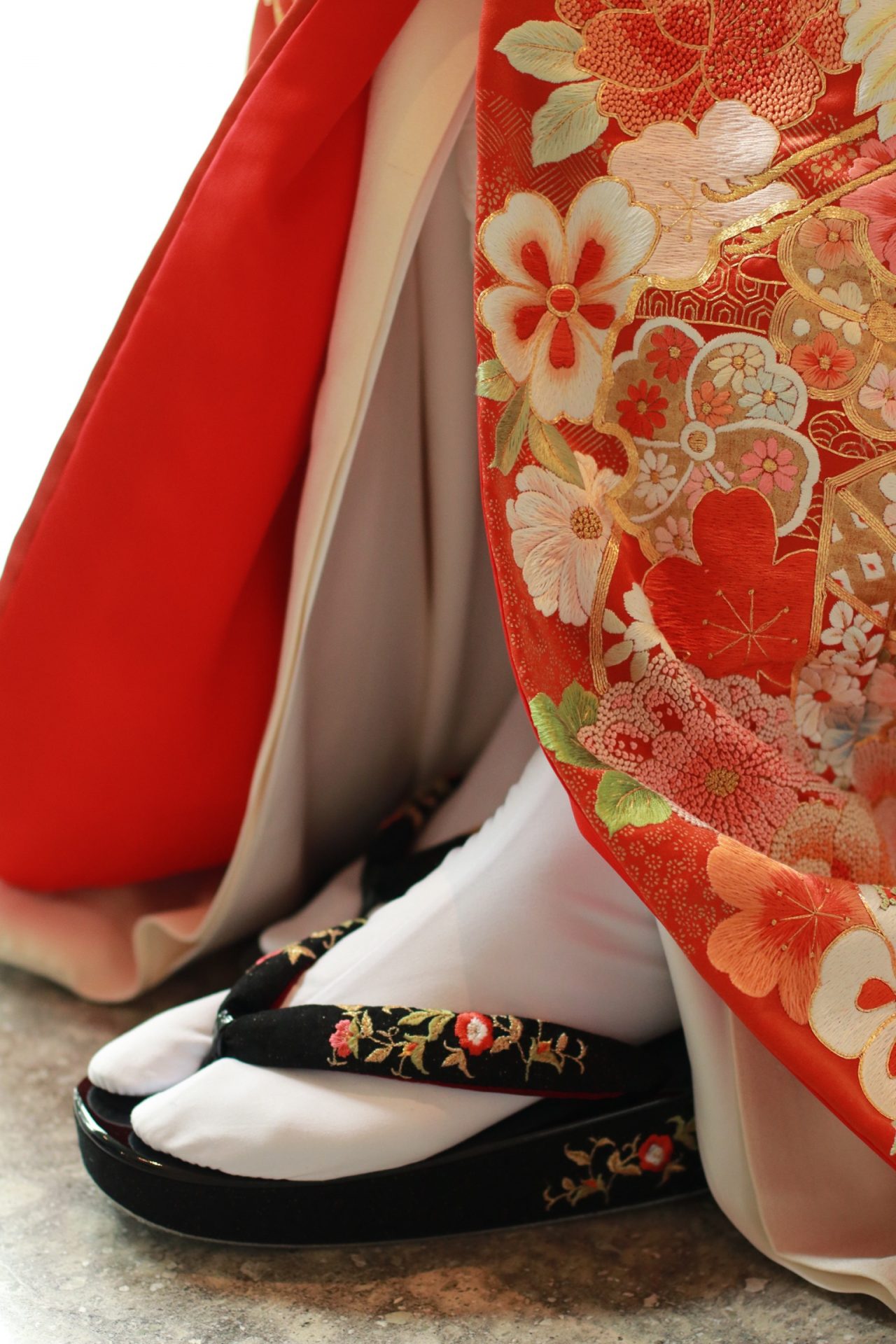 パレスホテル東京におすすめの赤の色打掛に、黒の草履を合わせたモダンなコーディネート提案