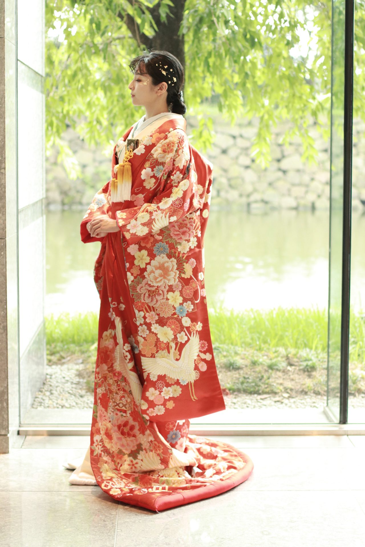 パレスホテル東京におすすめの新作赤字の色打掛、皇居の自然豊かな緑をバックにすると着物の美しさを柔らかく豊かに引き立てます