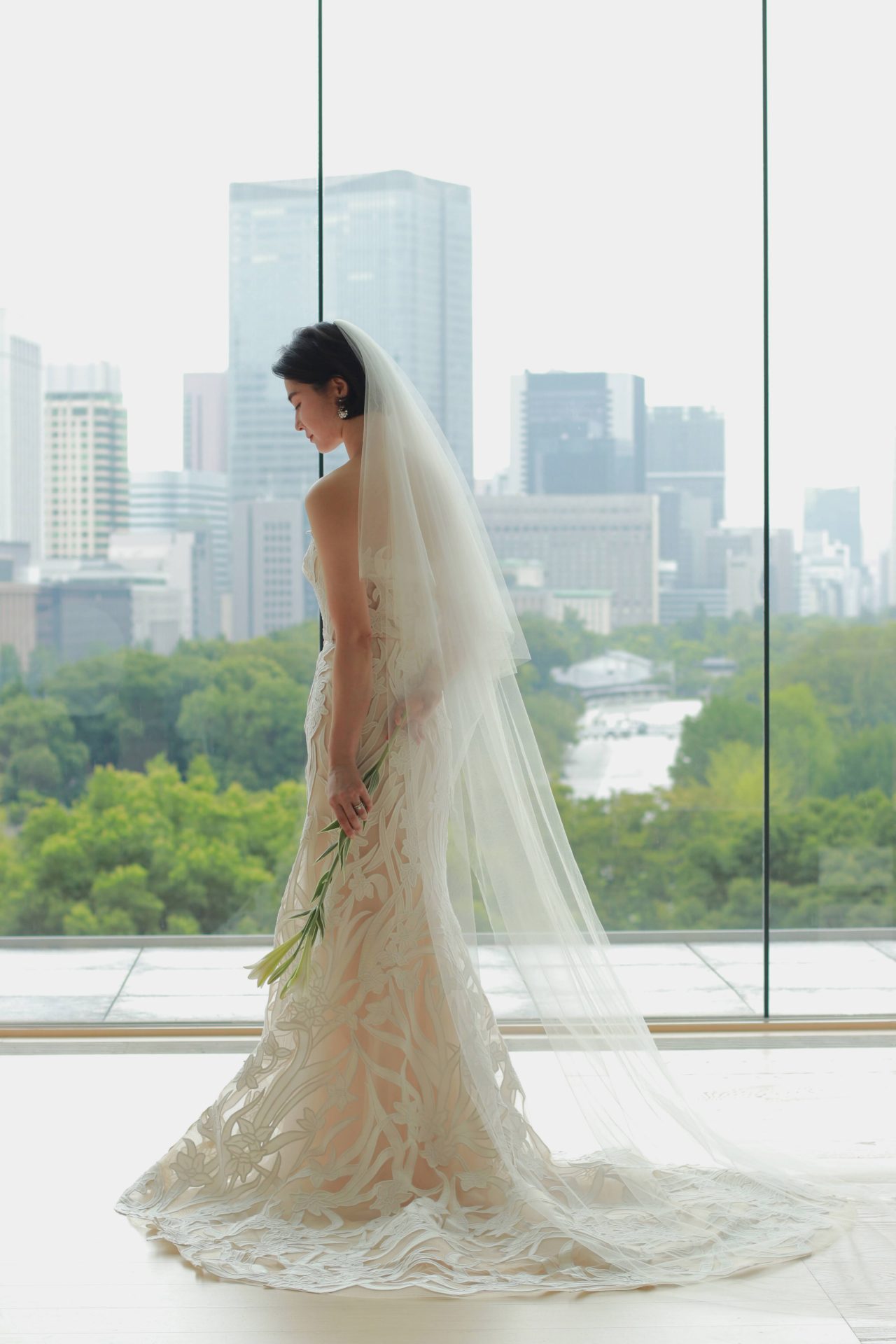 皇居と丸の内のビル群を目の前にしたパレスホテル東京のチャペルに総レースのマーメイドラインのウェディングドレスがマッチします