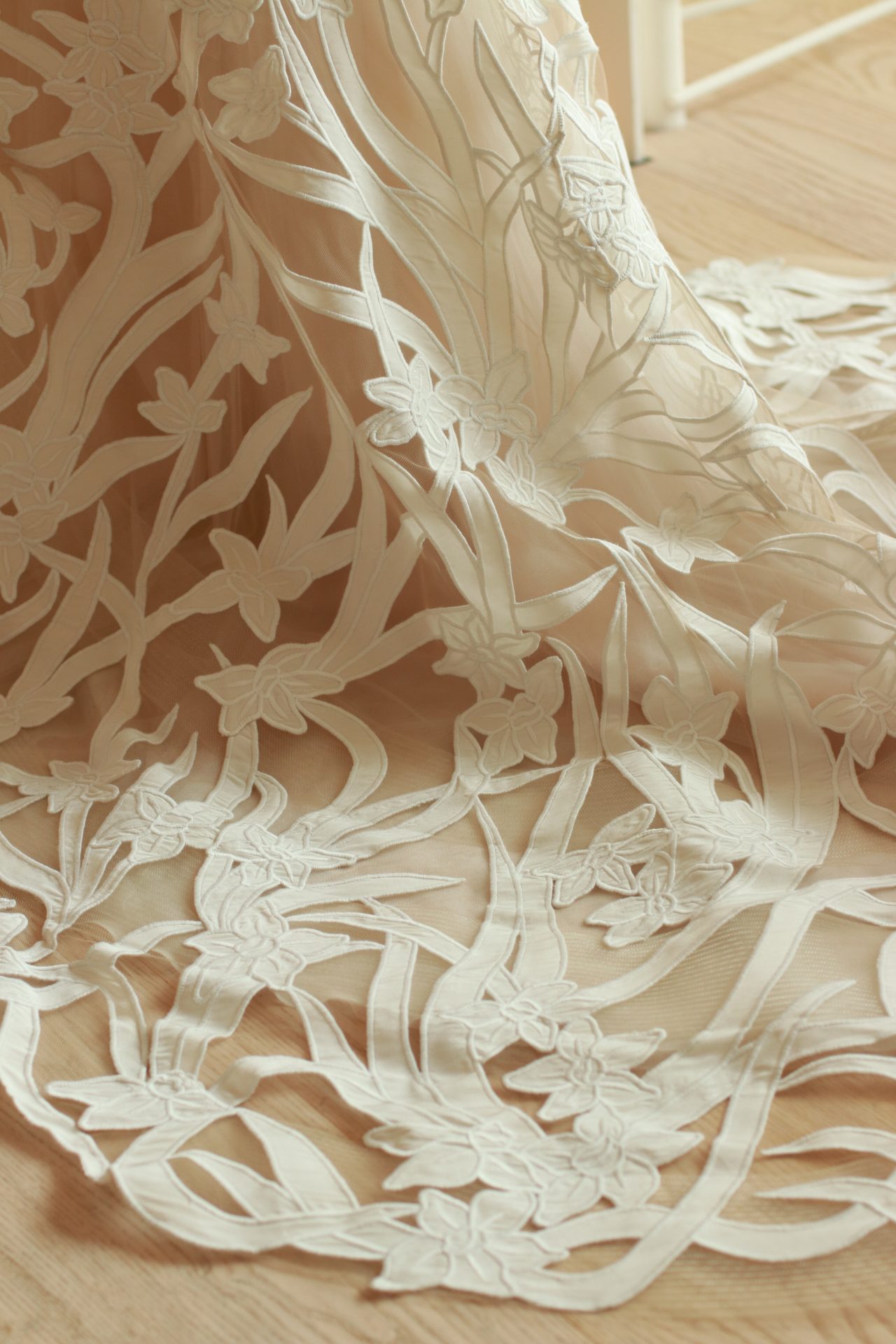 ザトリートドレッシングアディション店に入荷した新作ウェディングドレスは、ベージュカラーのチュールの上にカットワークレースが施されており、お写真映えする一着です