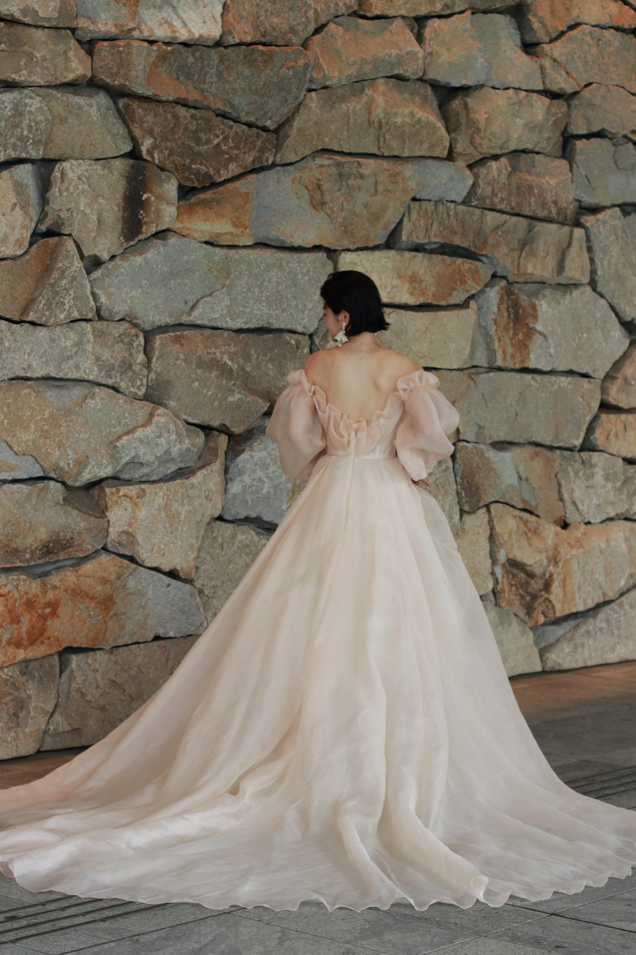 ロングトレーンのウェディングドレスはクラシックな印象になりますが、オフショルダーデザインと合わさる事でモダンなバックスタイルを叶えます