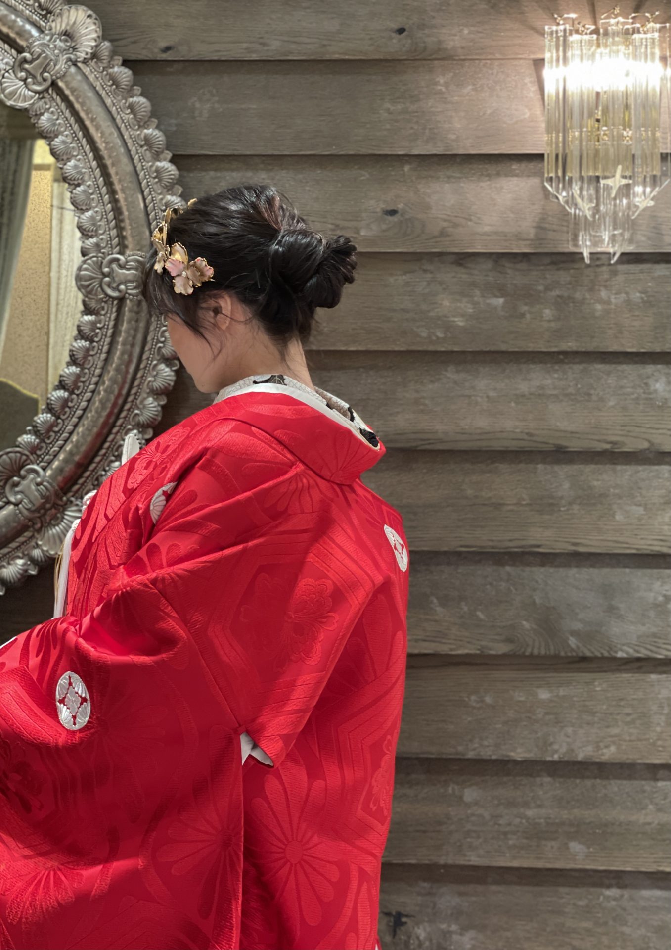 お色直しにおすすめの赤地の色打掛に合わせたルーズにまとめたシニヨンのヘアスタイル