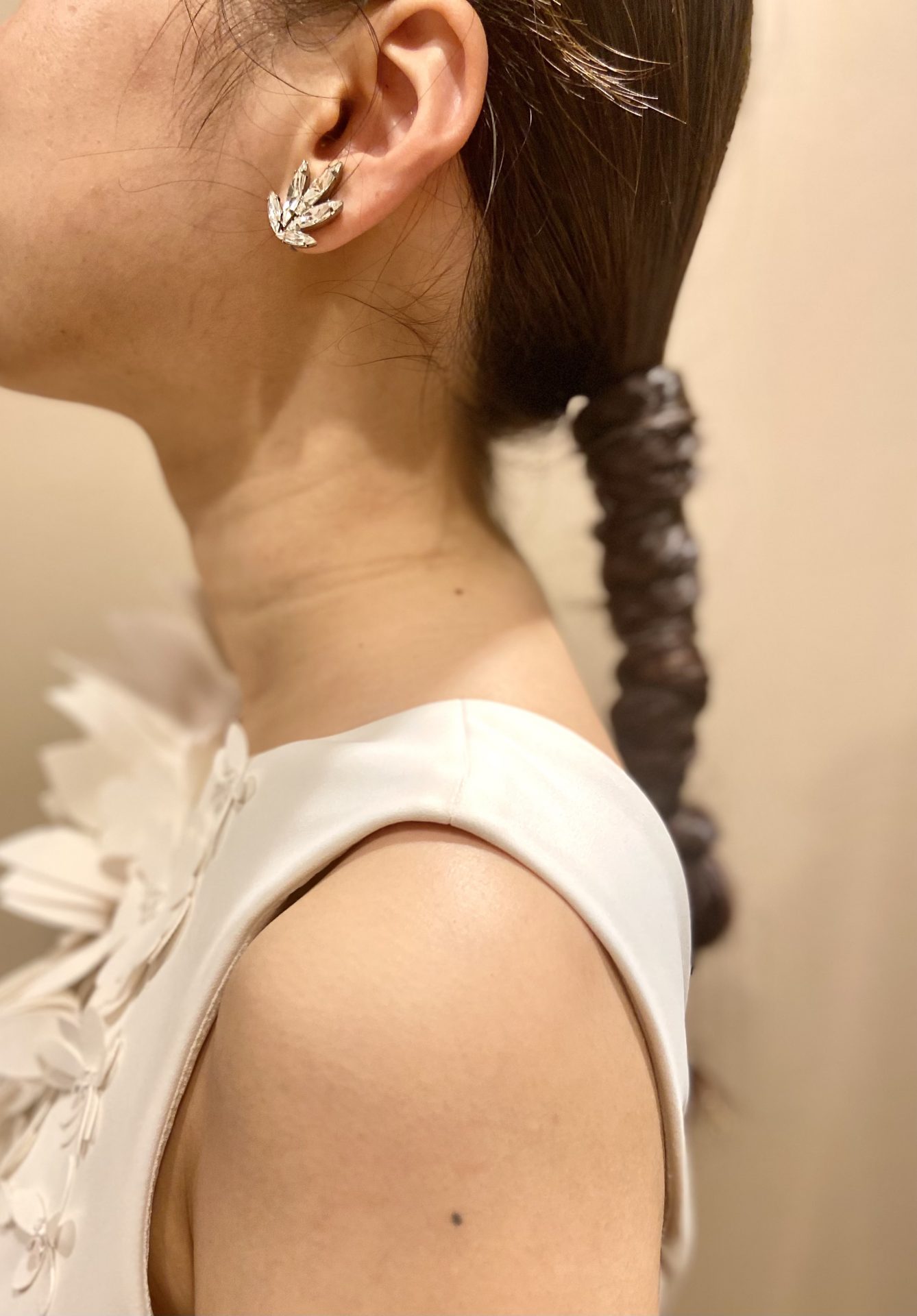 しっかりまとめあげたヘアスタイルに、ミニマムなイヤリングをあわせるコーディネート