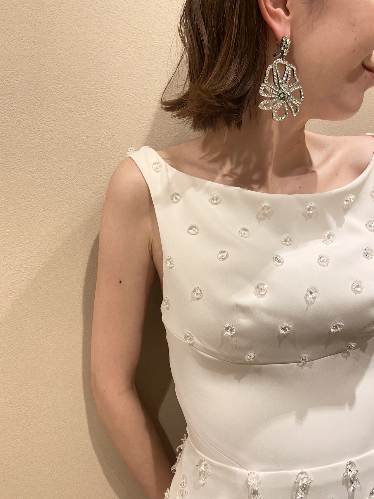 雫のようなクリアビジューが立体的なドレスに大ぶりなお花のイヤリングを身に纏うご新婦様