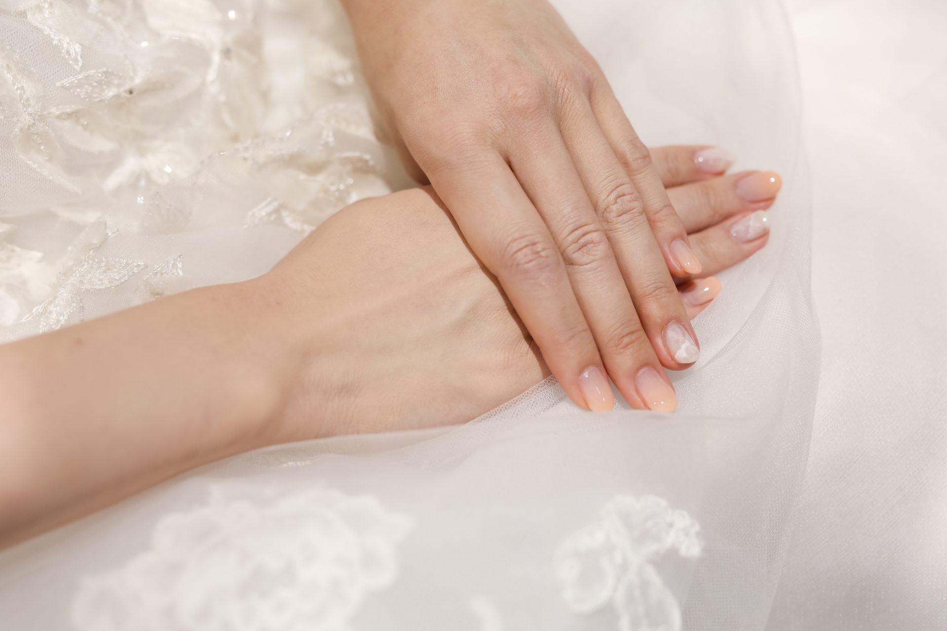 結婚式のネイルにはシンプルなコーラルカラーを合わせてナチュラれ可愛い印象に