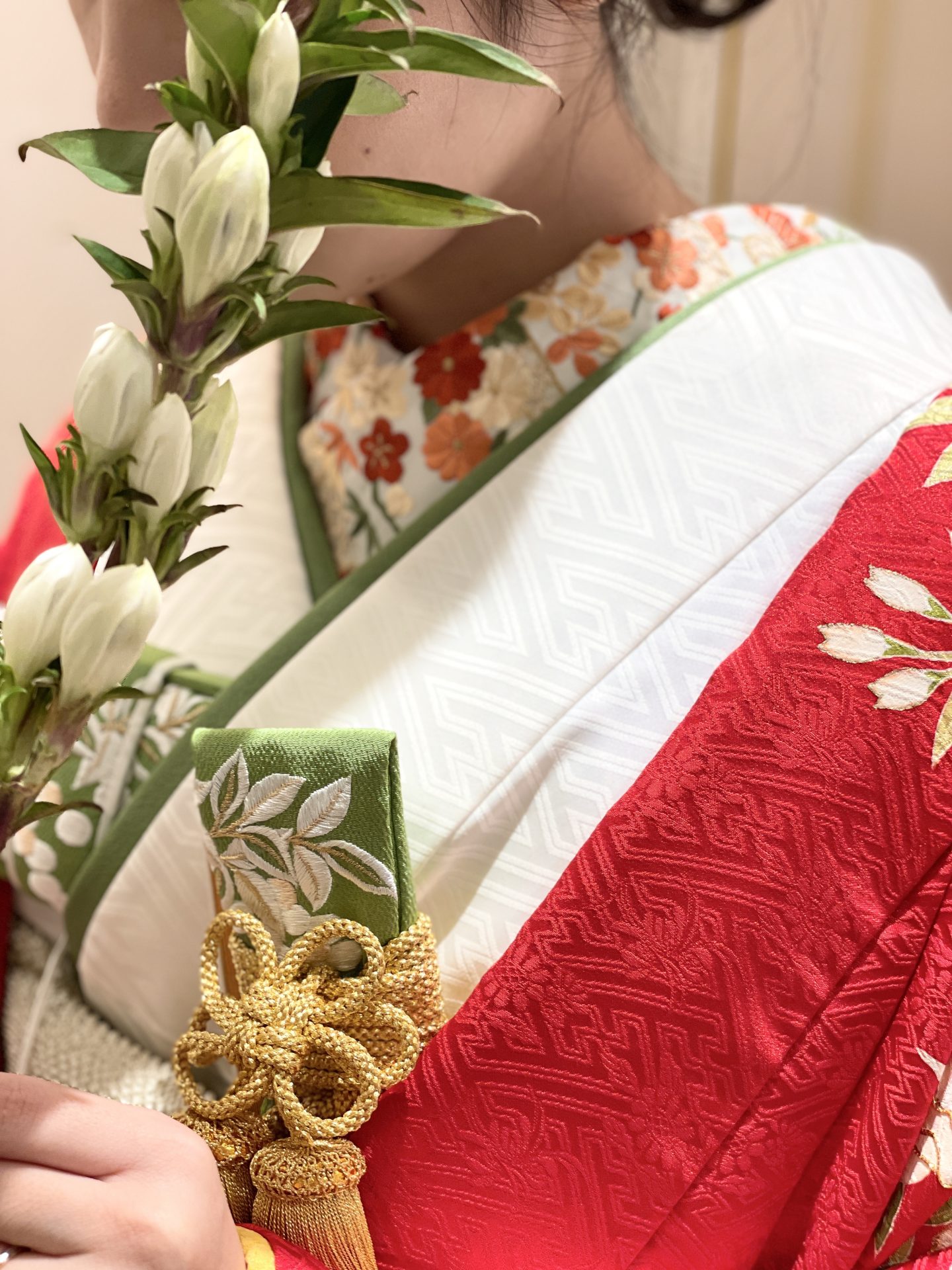 松竹梅の柄行の半襟が映える赤地の色打掛に合わせたリンドウの一輪ブーケ