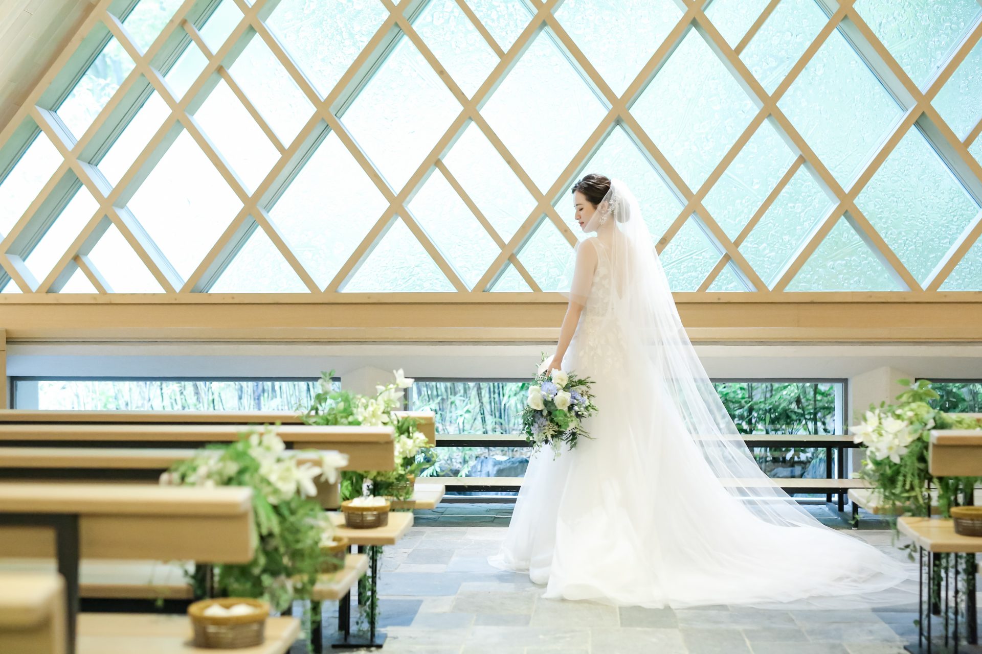 モニークルイリエのチュールのウェディングドレスには、無地のロングベールを合わせて神秘的な印象に