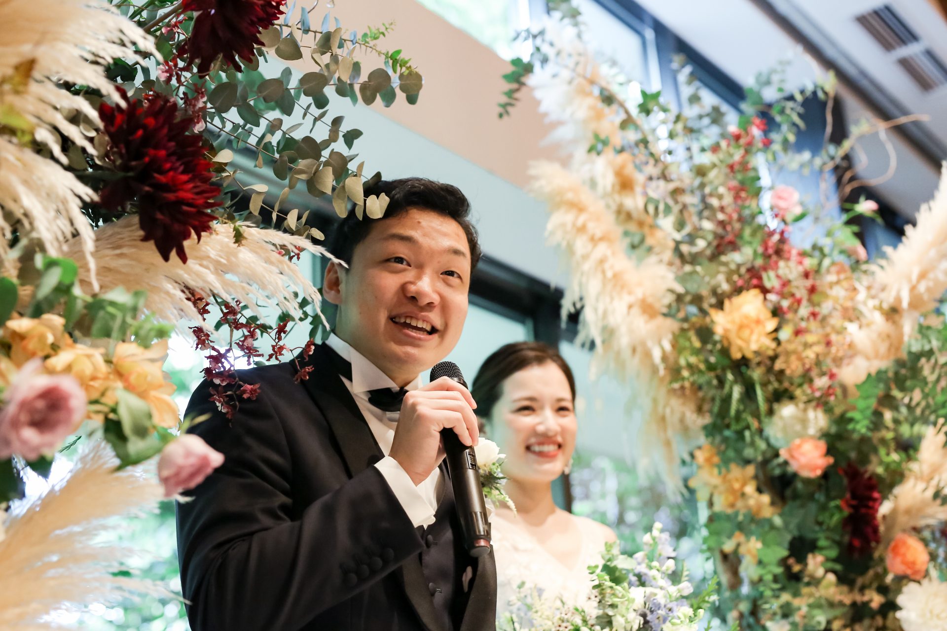 披露宴の高砂席に合わせるフラワーアーチはナチュラルフェミニンなテイストでアットホームな雰囲気に