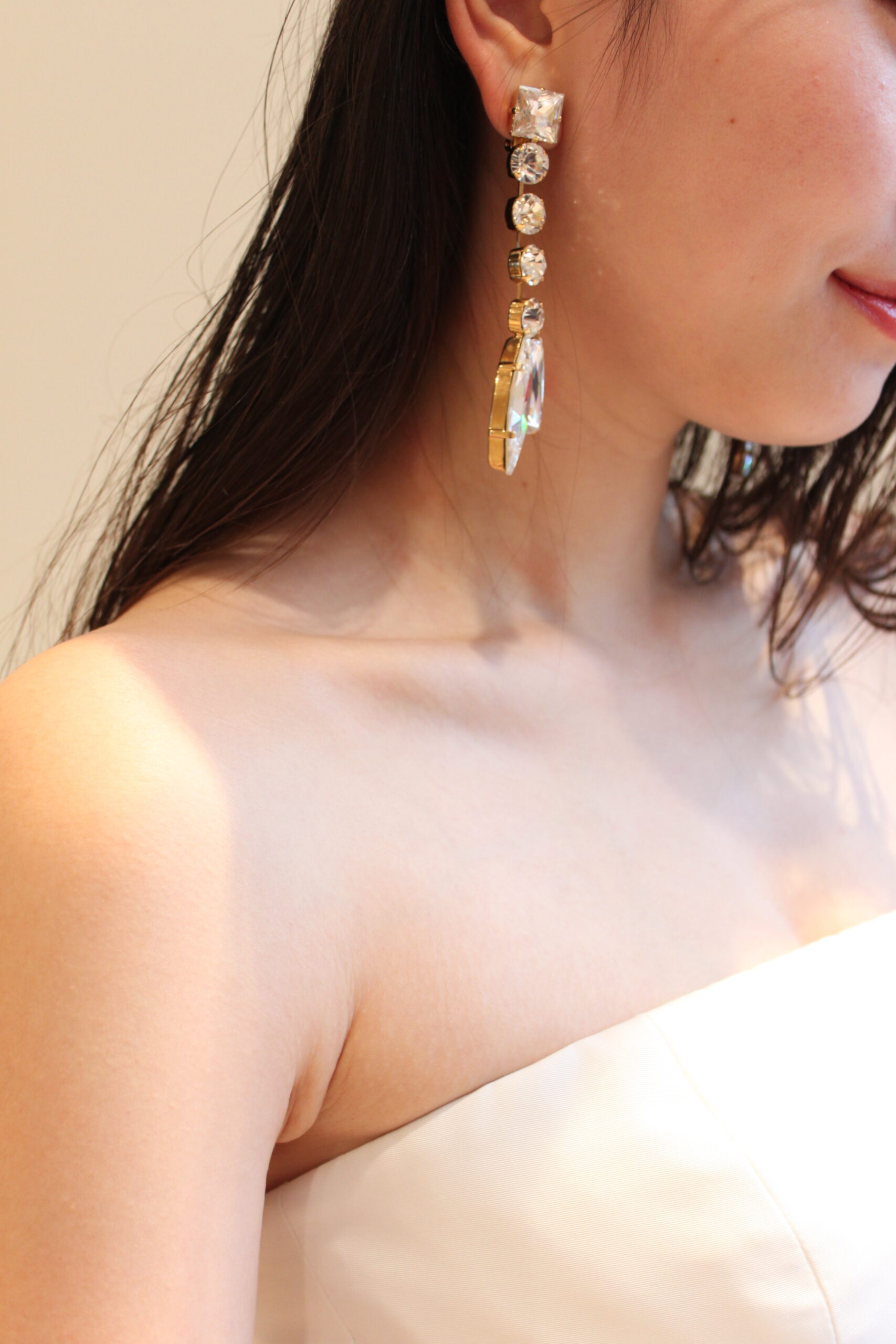 大ぶりのイヤリングが顔まわりに存在感を出すクリスタルゴールドイヤリング