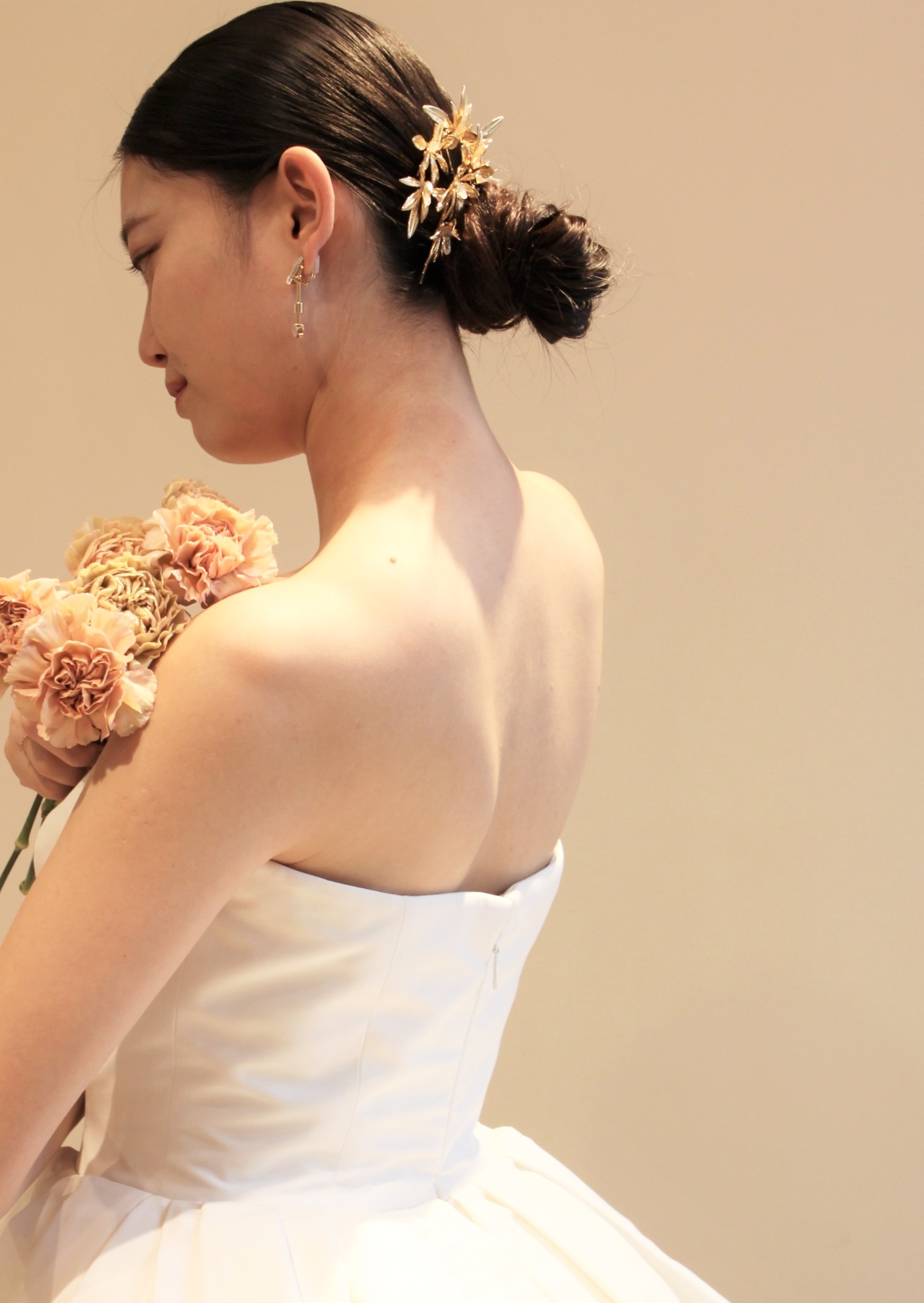 シンプルなウェディングドレスに合わせたゴールドアクセサリーのボンえとイヤリングはドレスに華やかさを加えアクセントになるブライダル小物