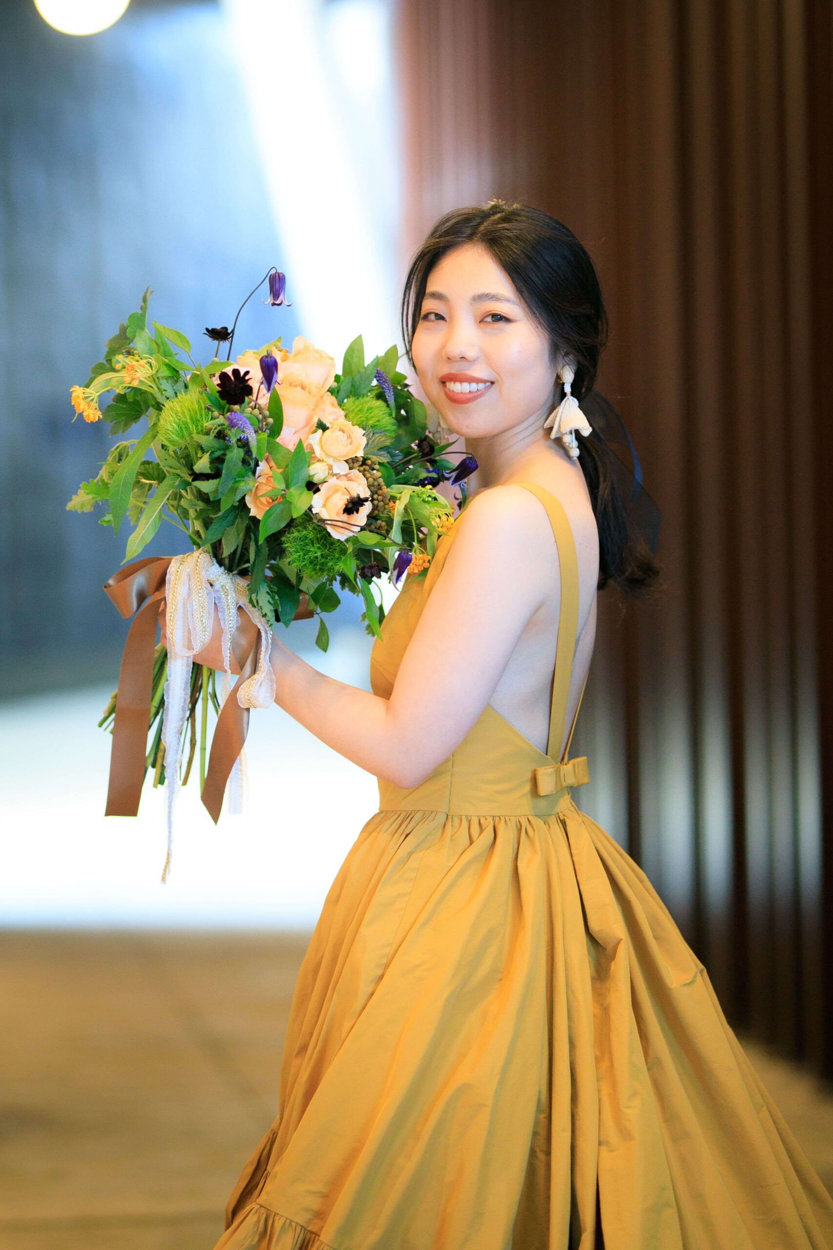 ザトリートドレッシングアディション店で人気のトリートメゾンのイエローのカラードレスにオスカーデラレンタのラフィアのイヤリングを合わせた花嫁のコーディネート