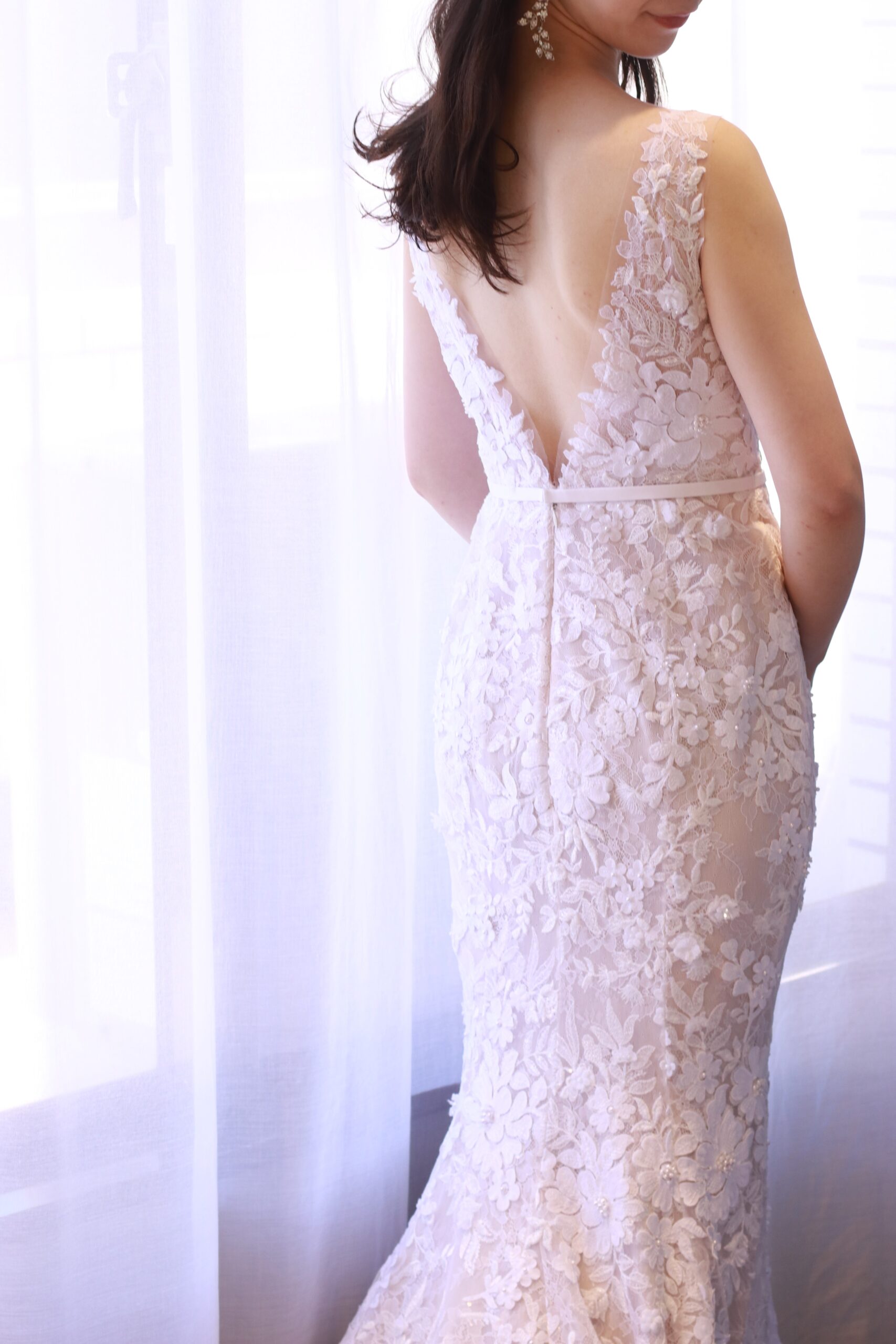 ミラズウイリンガーのウェディングドレスは薄っすらとピンクに色づく生地の上にフラワーモチーフが施され、立体感のあるディティールを生み出します。すべてのモチーフをデザイナーが配置することで360度どの角度からも美しい花嫁姿を演出いたします。