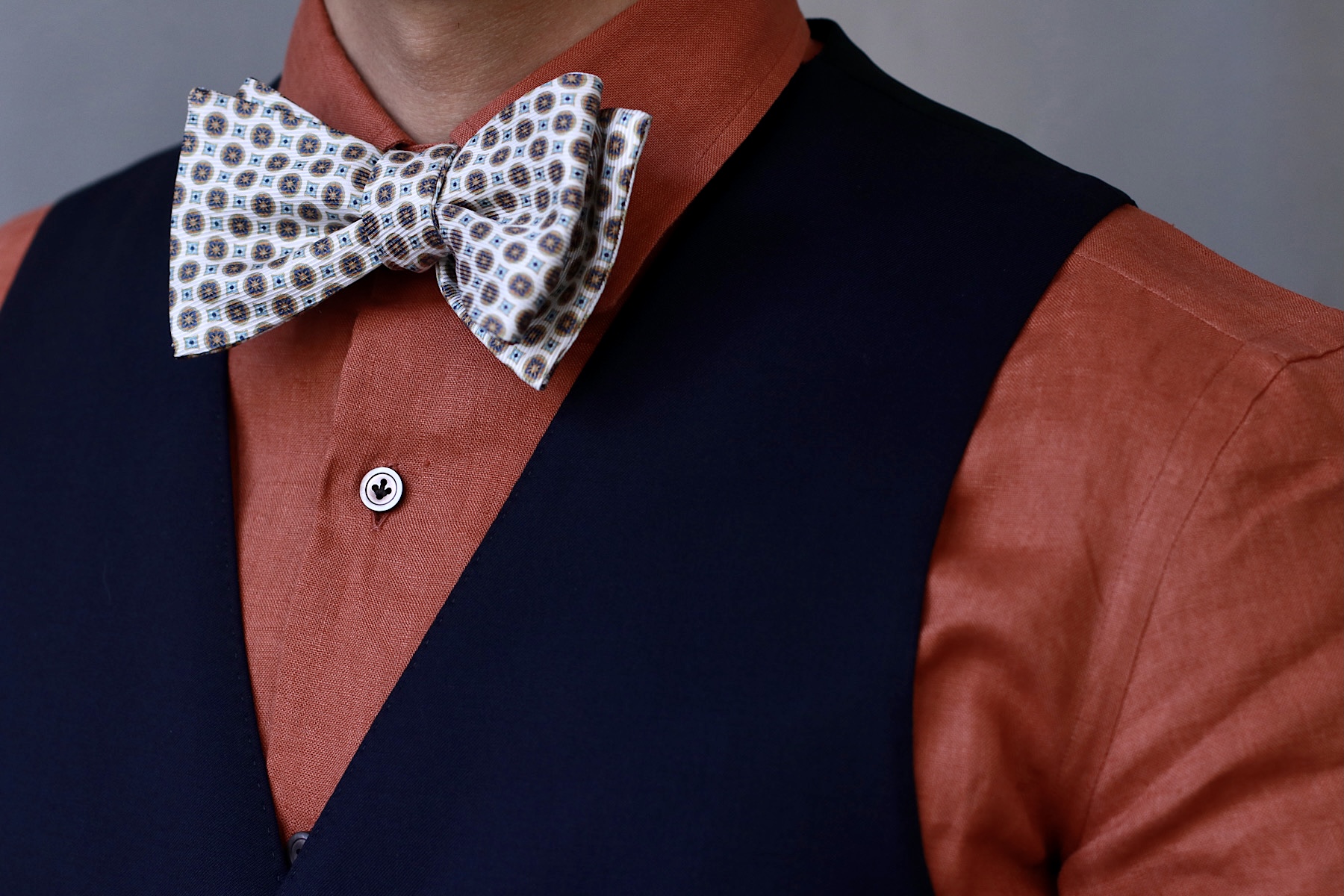 明るいカラーリングのシャツに白を基調としたタイを合わせた爽やかな春夏らしいスタイル