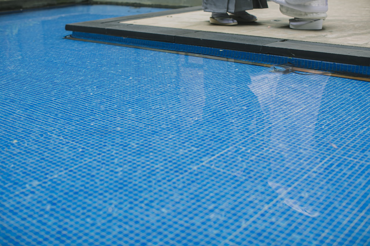 鮮やかなブルーが映えるプールサイドでの足元を写した写真は、ウィズザスタイルならではの一枚