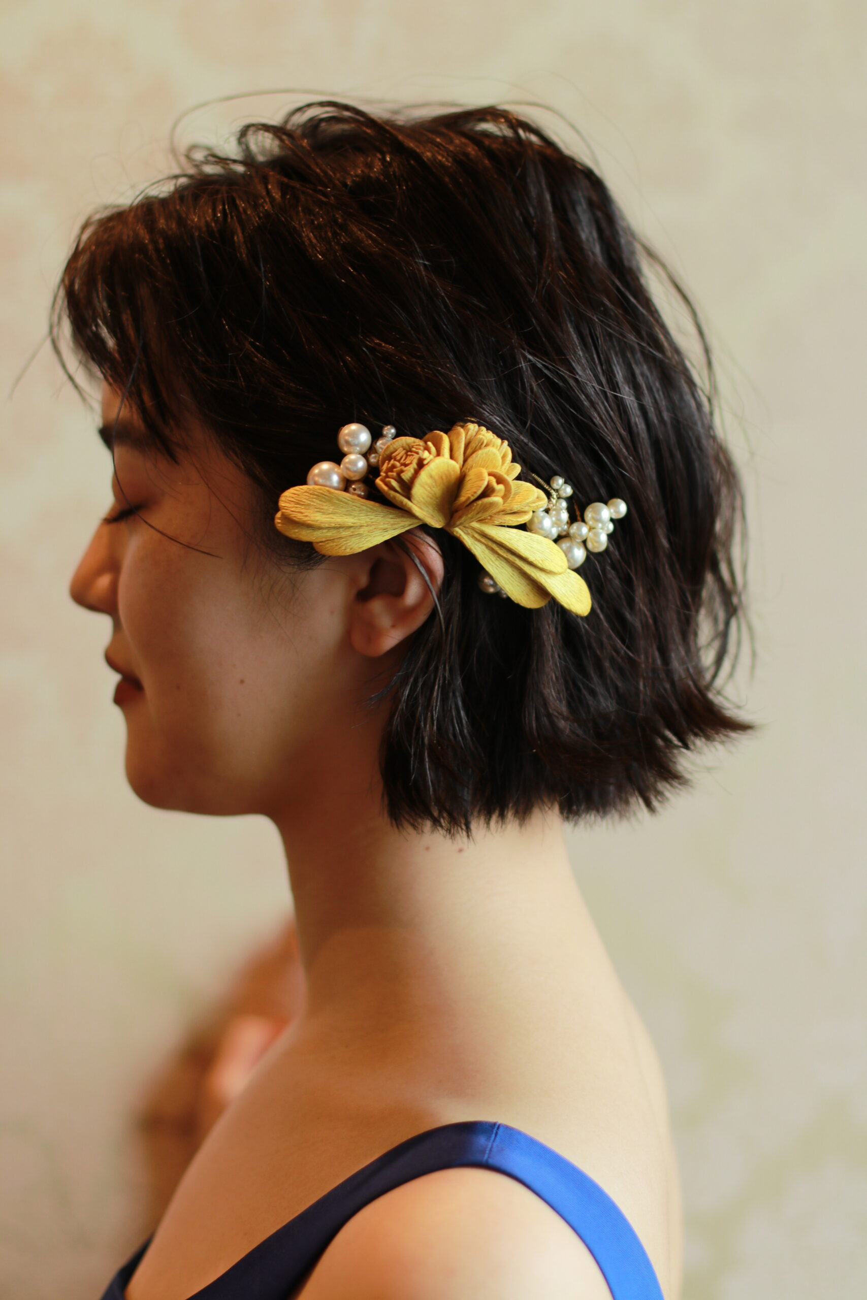 パーティーシーンであるご披露宴のお色直しには、挙式よりもカジュアルダウンしたラフなダウンヘアスタイルにお顔周りにだけお花の髪飾りとパールのアクセサリーをプラスしたお洒落なコーディネートがおすすめです