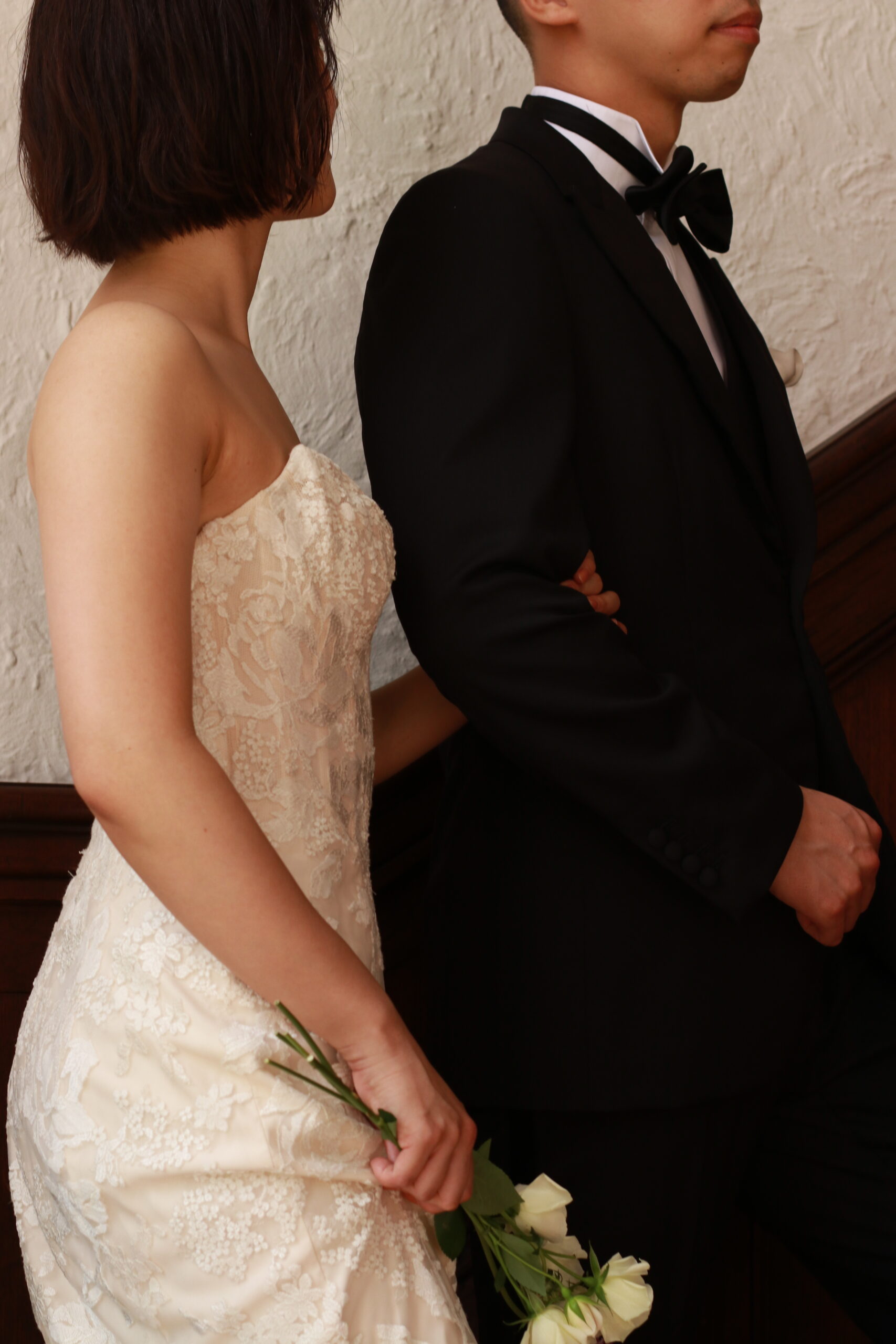 ブラックのタキシードに身を包むご新郎様とクラシックなレースの施されたアンバルジのマーメイドラインのウエディングドレスを纏う花嫁様が赤坂プリンスクラシックハウスの螺旋階段に歩みを進めると、フォトスポットであるステンドグラスから自然光がたっぷりと差し込みます。