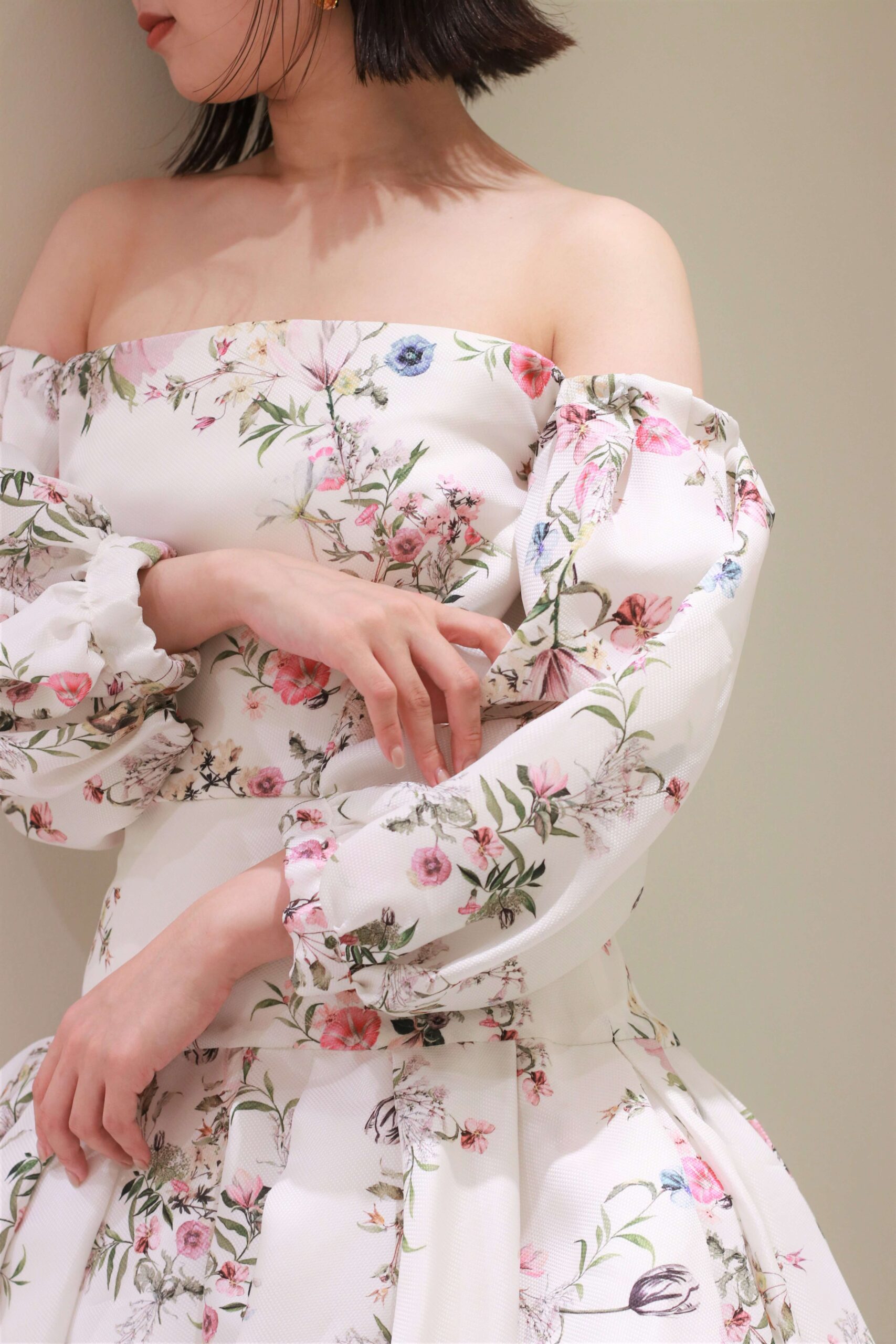 トリート花嫁に人気のブランド、モニークルイリエの新作カラードレスは、アイキャッチ―でフェミニンなフラワープリント、オフショルダーかつパフスリーブのトレンドが詰まった一着です