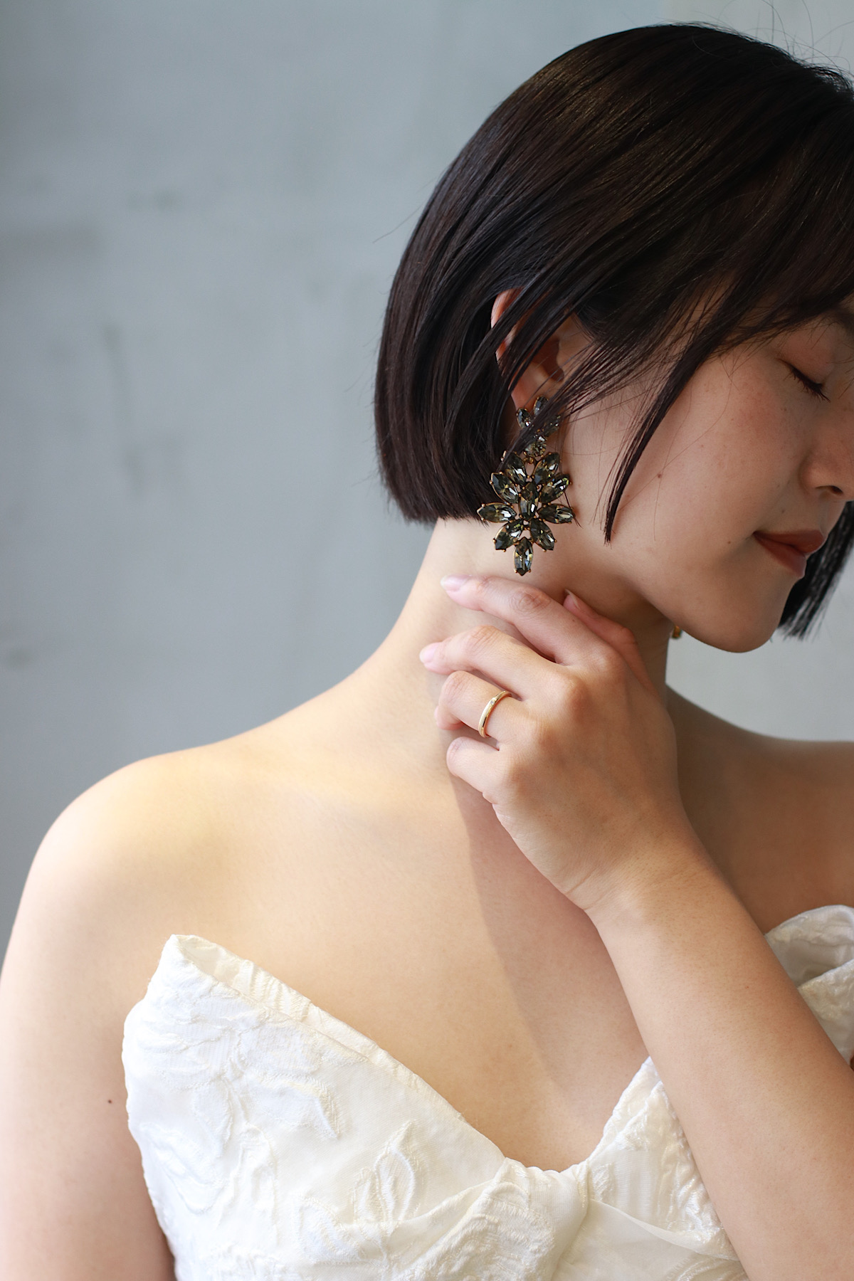 洗練された他にはないオスカーデラレンタらしいブラックストーンの大ぶりなイヤリングがミニボブから覗く、モダンでファッショナブルなスタイリング