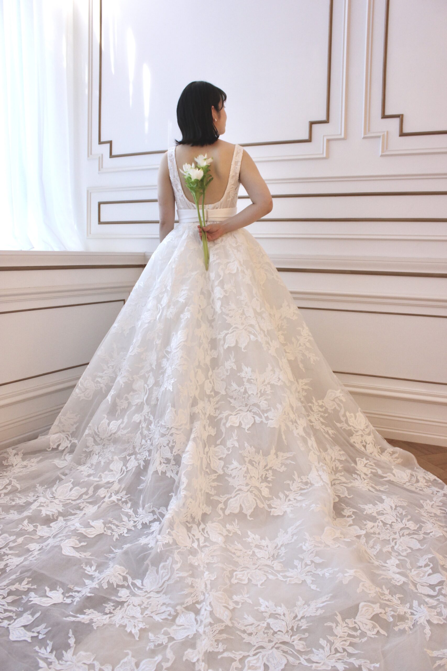 トレーンが長く広がりが綺麗なボリュームのあるウェディングドレスには白のシンプルなお花を合わせて