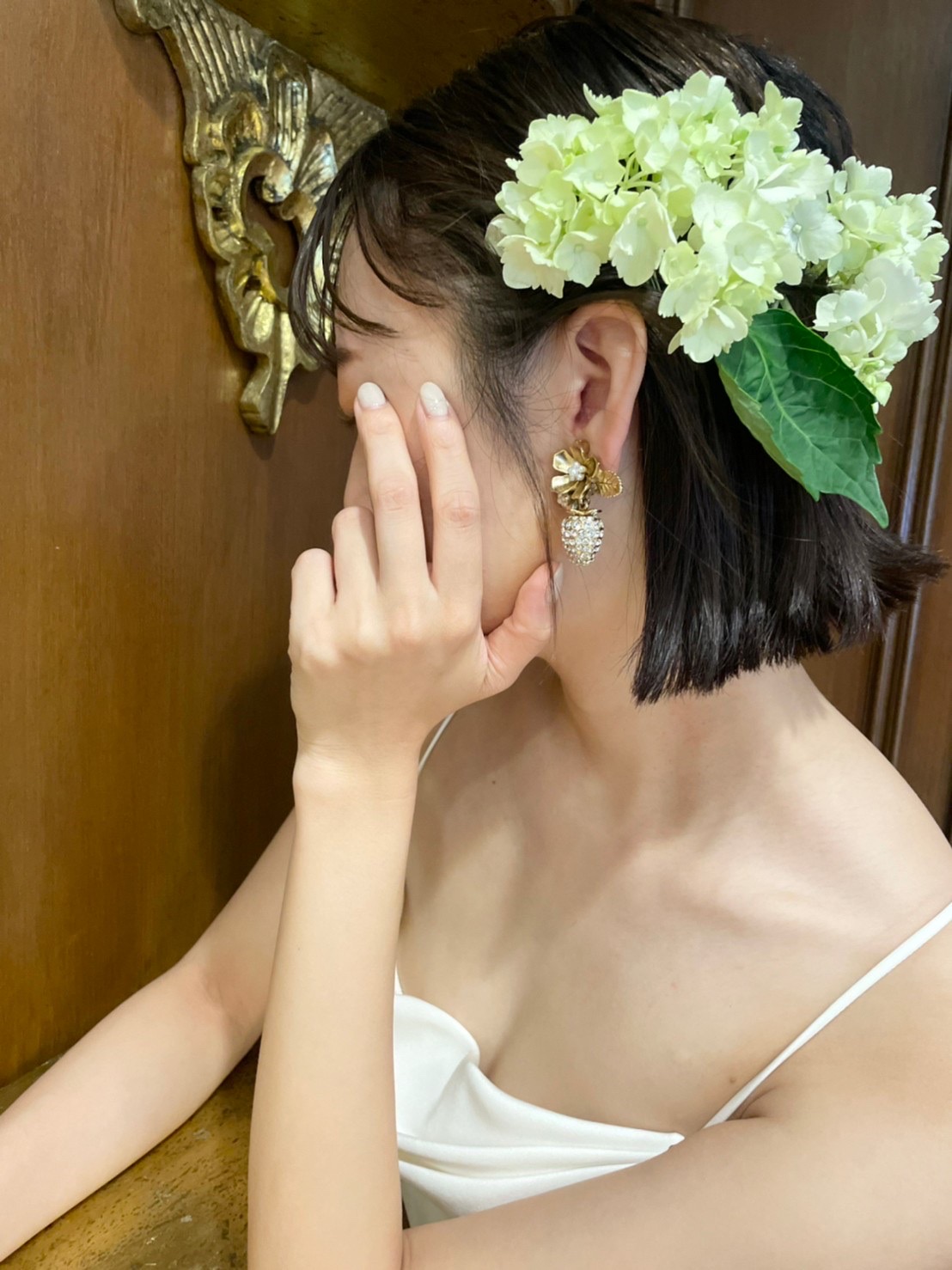 生花のヘアアレンジとストロベリーモチーフのゴールドのイヤリングでおしゃれ花嫁の大人フェミニンなコーディネート