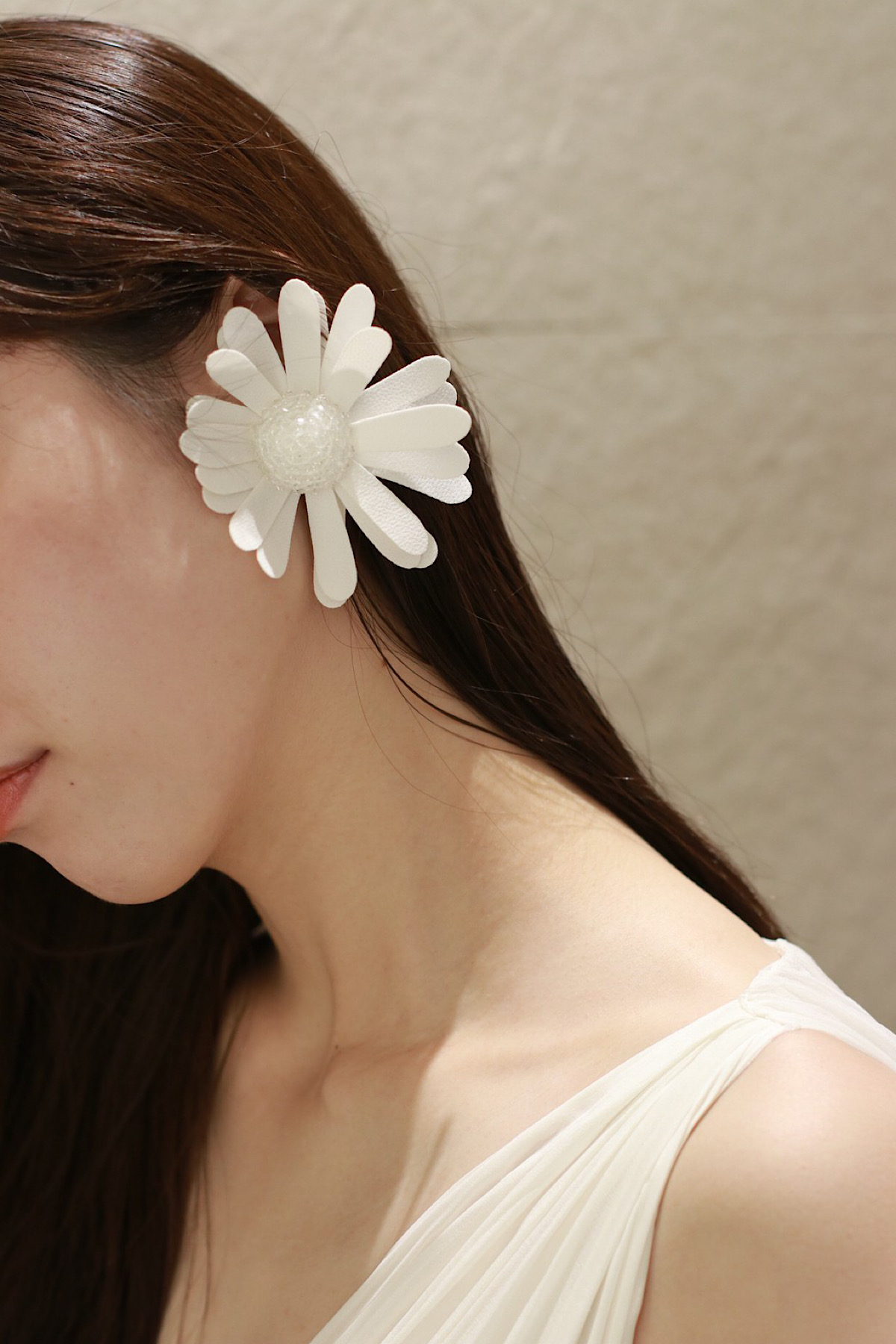 フラワーモチーフの大ぶりなイヤリング、中央部分は透明なビーズであしらわれ、花弁はマットなクレープ素材で作られたファッショナブルで他にはないデザイン性のあるイヤリングです