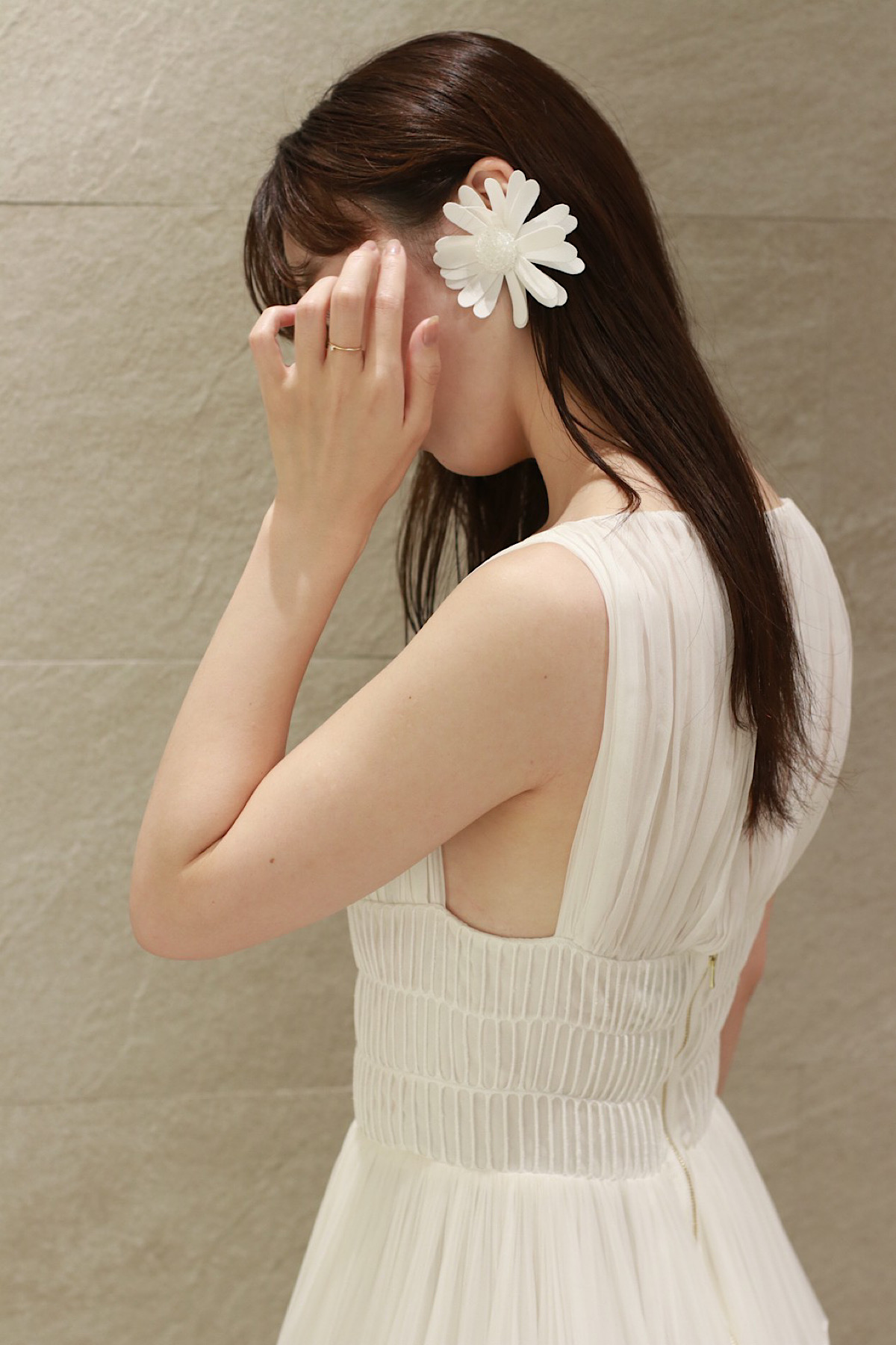 ビクターアンドロルフのアイキャッチーなフラワーモチーフのイヤリングと繊細なプリーツが美しいファッショナブルなコーディネートを纏う花嫁姿