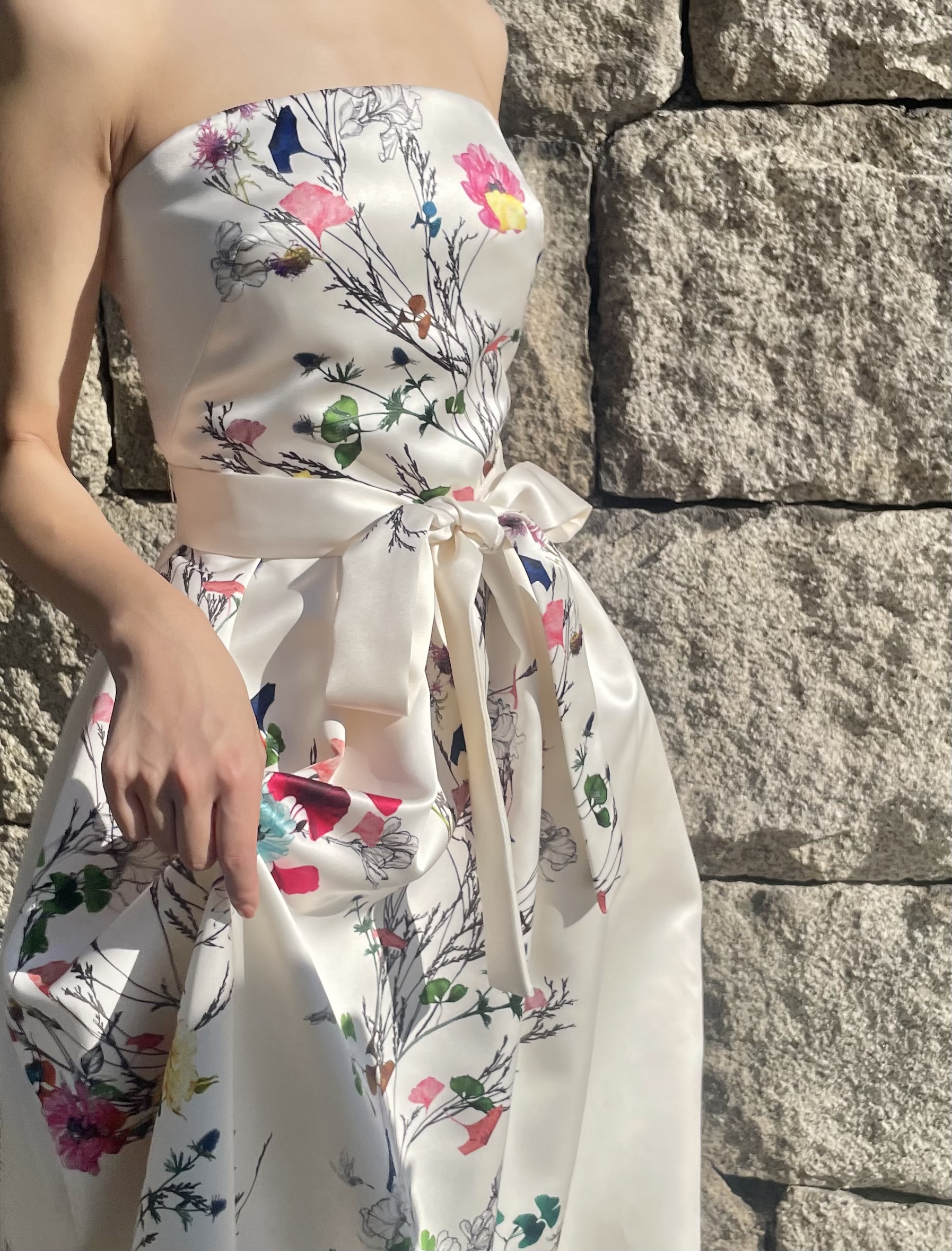 ウエストの大きなリボンがポイントの花柄プリントのカラードレスは、女性らしいシルエットを際立たせスタイルよくみせてくれるカラードレス