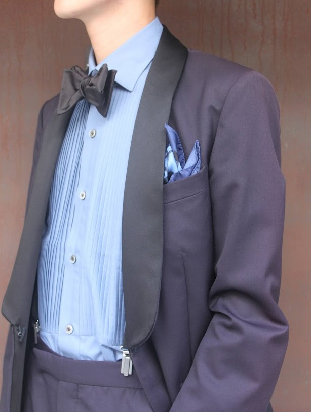 ネイビーのフォーマルタキシードのカジュアルダウンスタイル。ブルーのプリーツシャツにブラックのボウタイ。ギンガムチェックのブルーチーフでカジュアルになり過ぎない落ち着いたカジュアルスタイル。