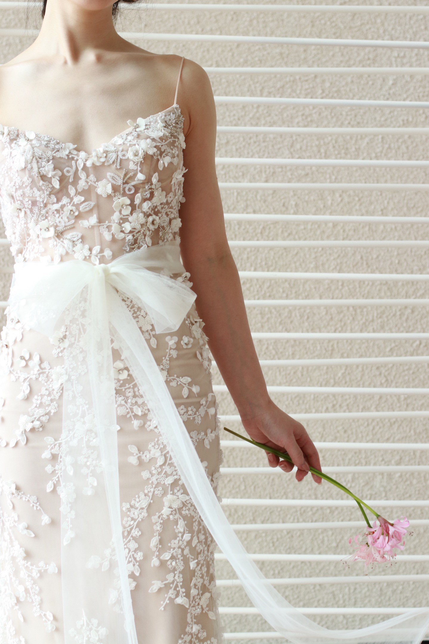 リズマルチネスの新作ウェディングドレスは、マーメイドラインです。腰元に柔らかなチュールのリボンがあしらわれており、上品かつしなやかな女性らしい印象をより一層引き立てます。