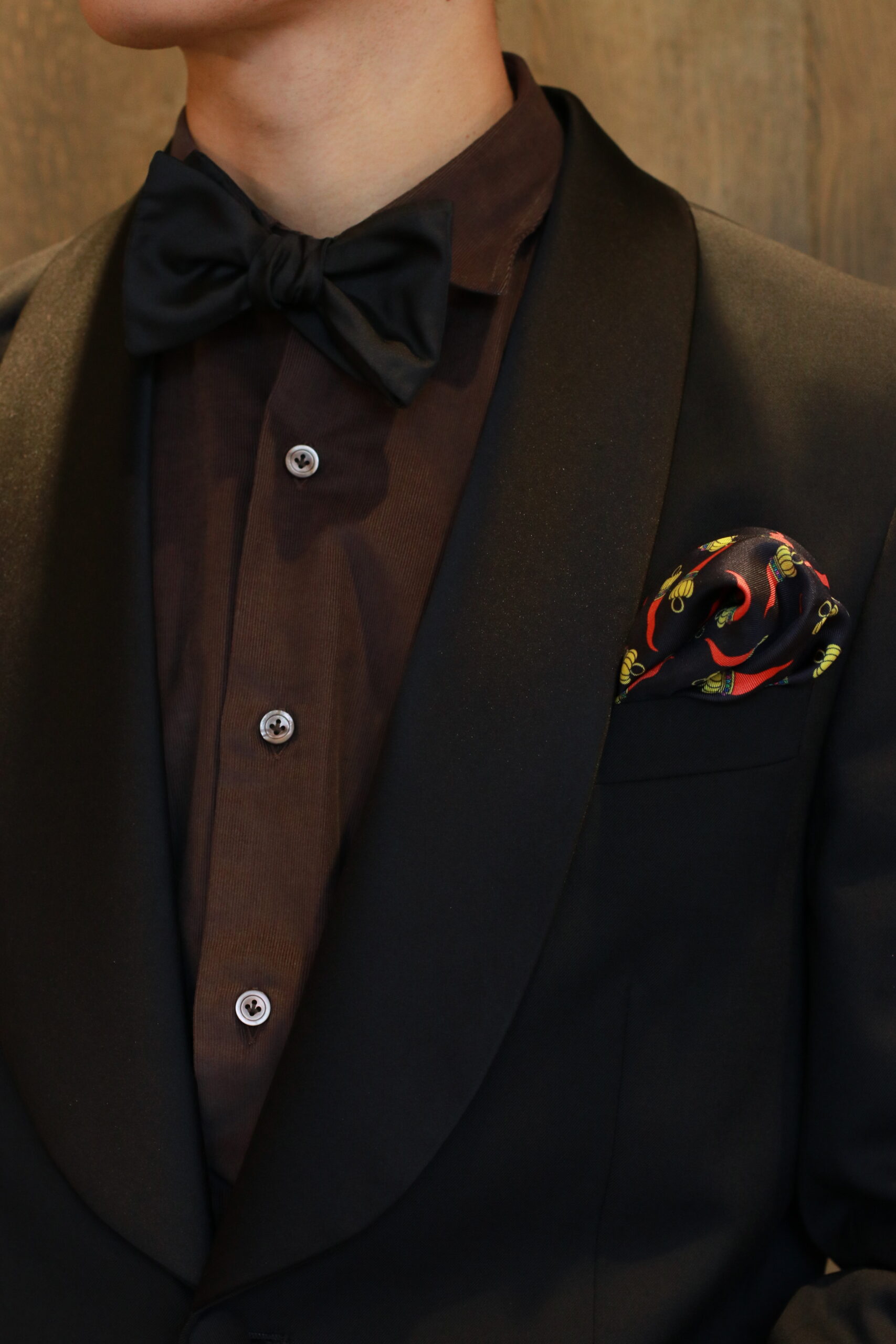 新作チーフはブラックのサテン地と唐辛子がモチーフの赤と黄色のキャッチーなデザイン、胸元アップの画角により当日のゲストの方の目線を感じることができます