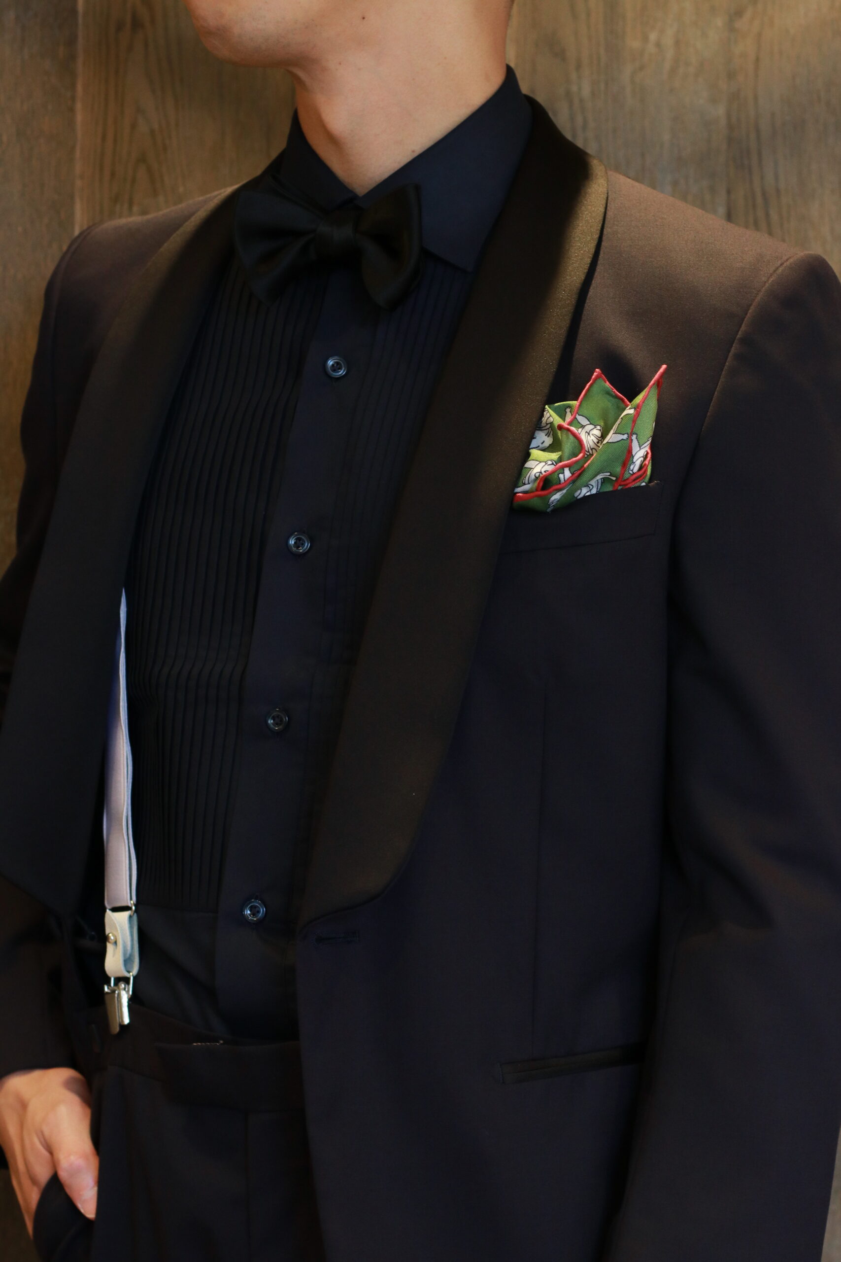 THETREATDRESSINGへ入荷した新郎小物の新作チーフ、ダークトーンのシックなタキシードから覗く上品な緑と赤とグレーの色味のチーフはよく見るとブルドックが描かれているキャッチーナデザインです