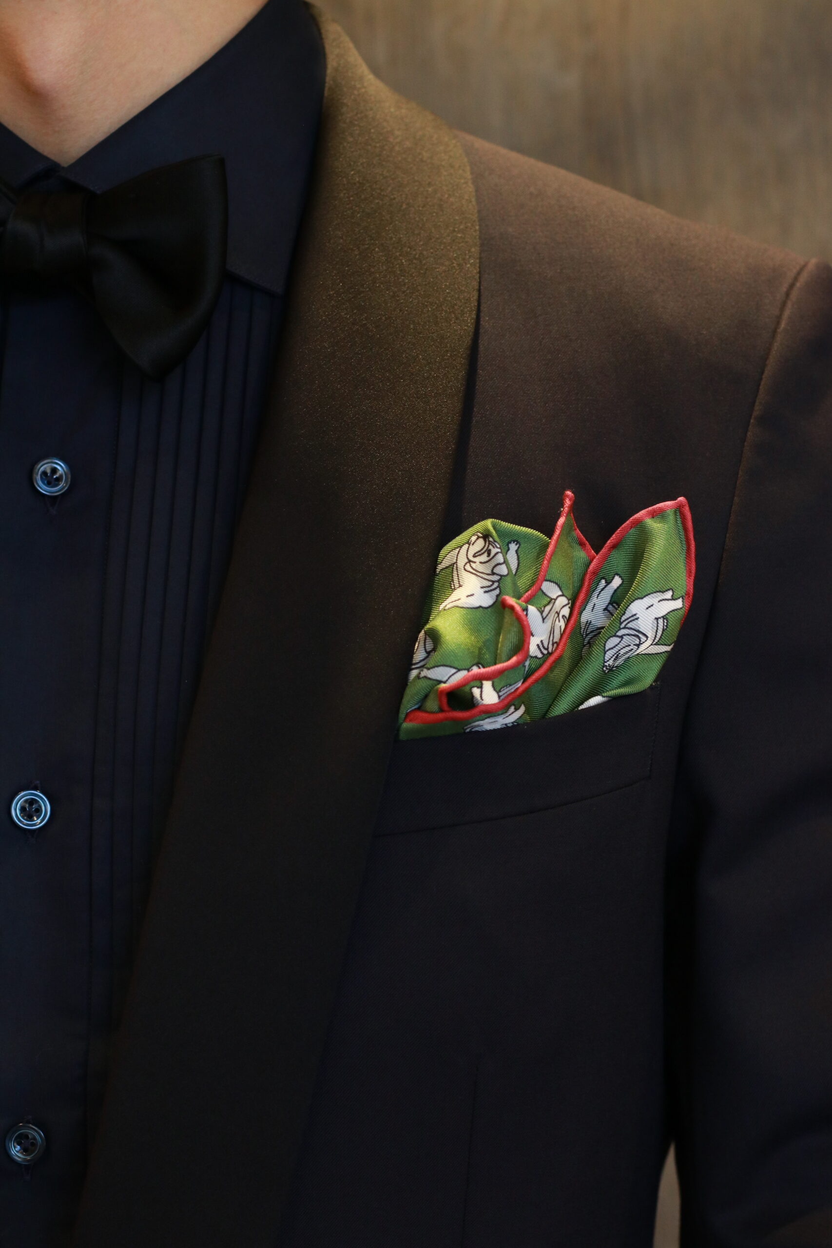 フォーマルタキシードにブルドックの新作チーフが遊び心のあるコーディネート、深緑と差し色のボルドーの色合わせが洗練されたお色直しスタイルへ昇華されます