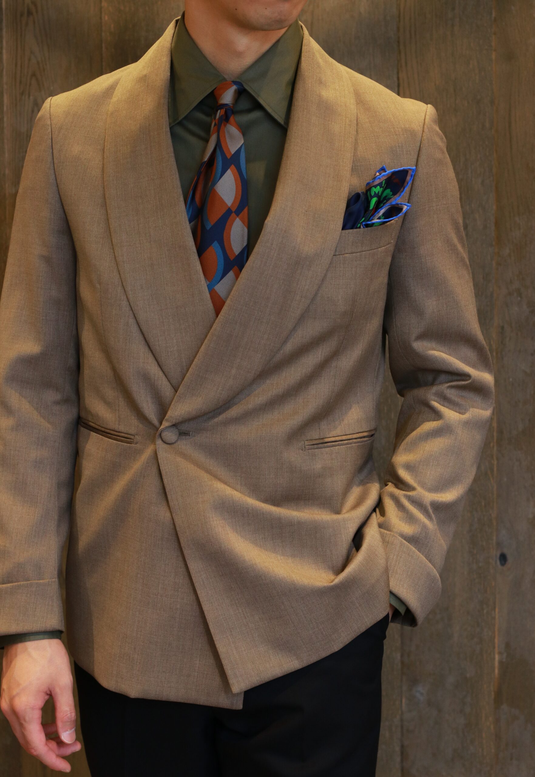 上品なブラウンとアースカラーでまとめられた小物使いが落ち着いたエレガントな新郎様のお色直しスタイル、首元のスカーフタイとリンクした色使いの新作チーフはコーディネートを邪魔することなくそっと花を添えるアイテムです