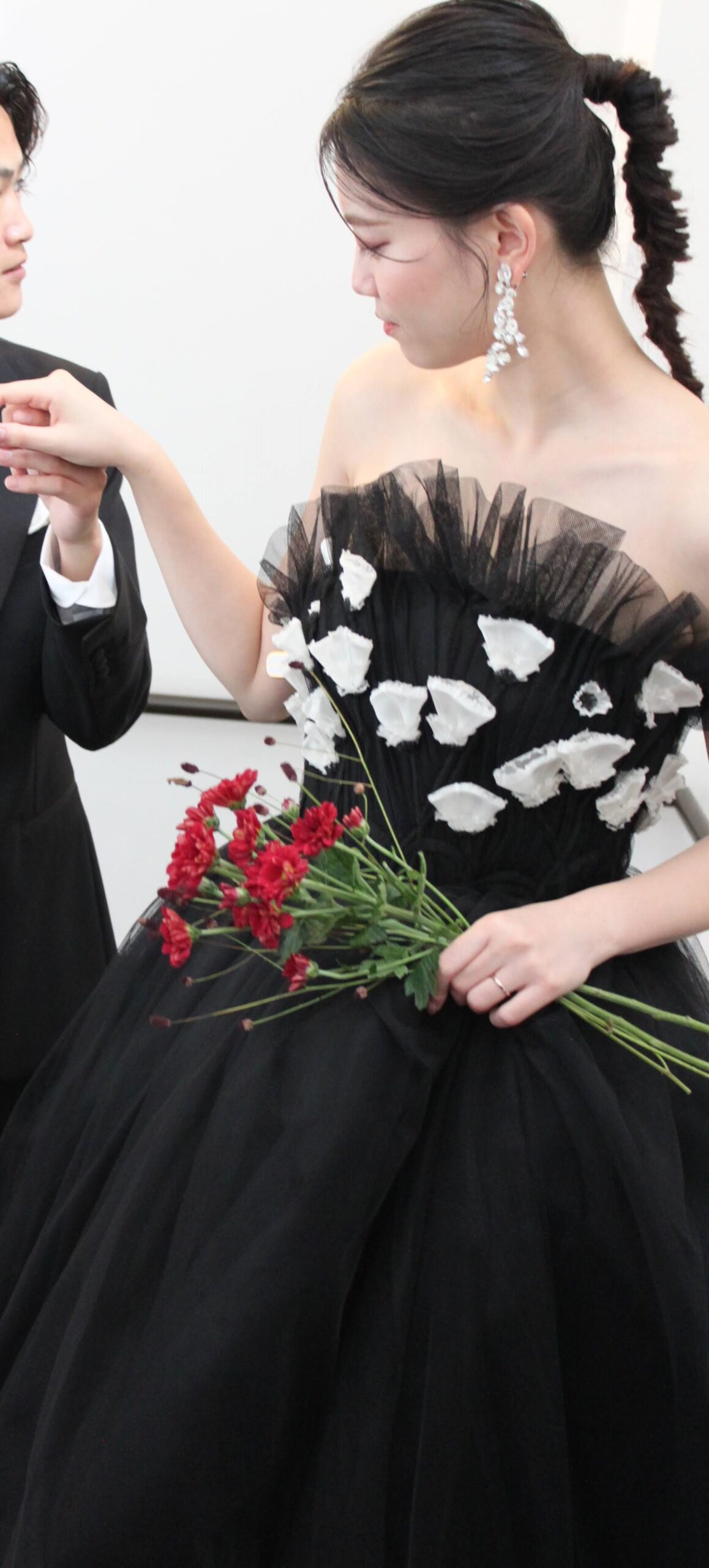 凛とした表情のブラックのカラードレスはエッジの効いたポニーテールと大振りのフラワーモチーフのイヤリングが映えます