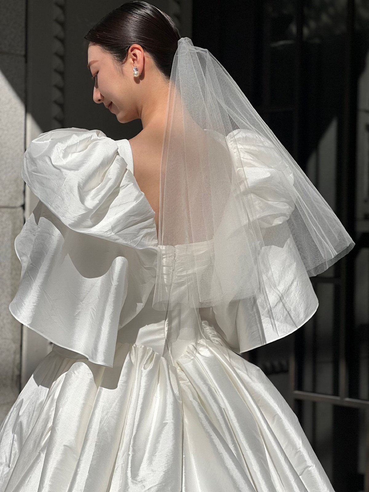 ショートベールとタイトなシニヨンでつくるコーディネートが美しいプリンセスラインのウェディングドレス