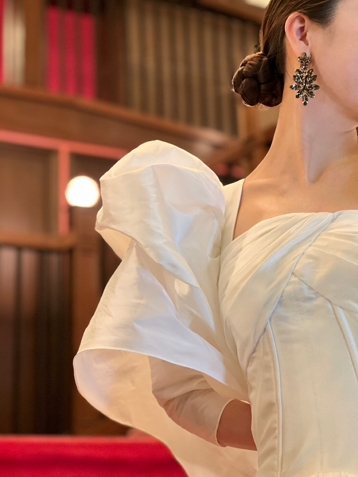 披露宴スタイルにぴったりのオスカー デ ラ レンタのブラックのイヤリングと合わせたパワーショルダーが美しいシンプルなウェディングドレスのコーディネート