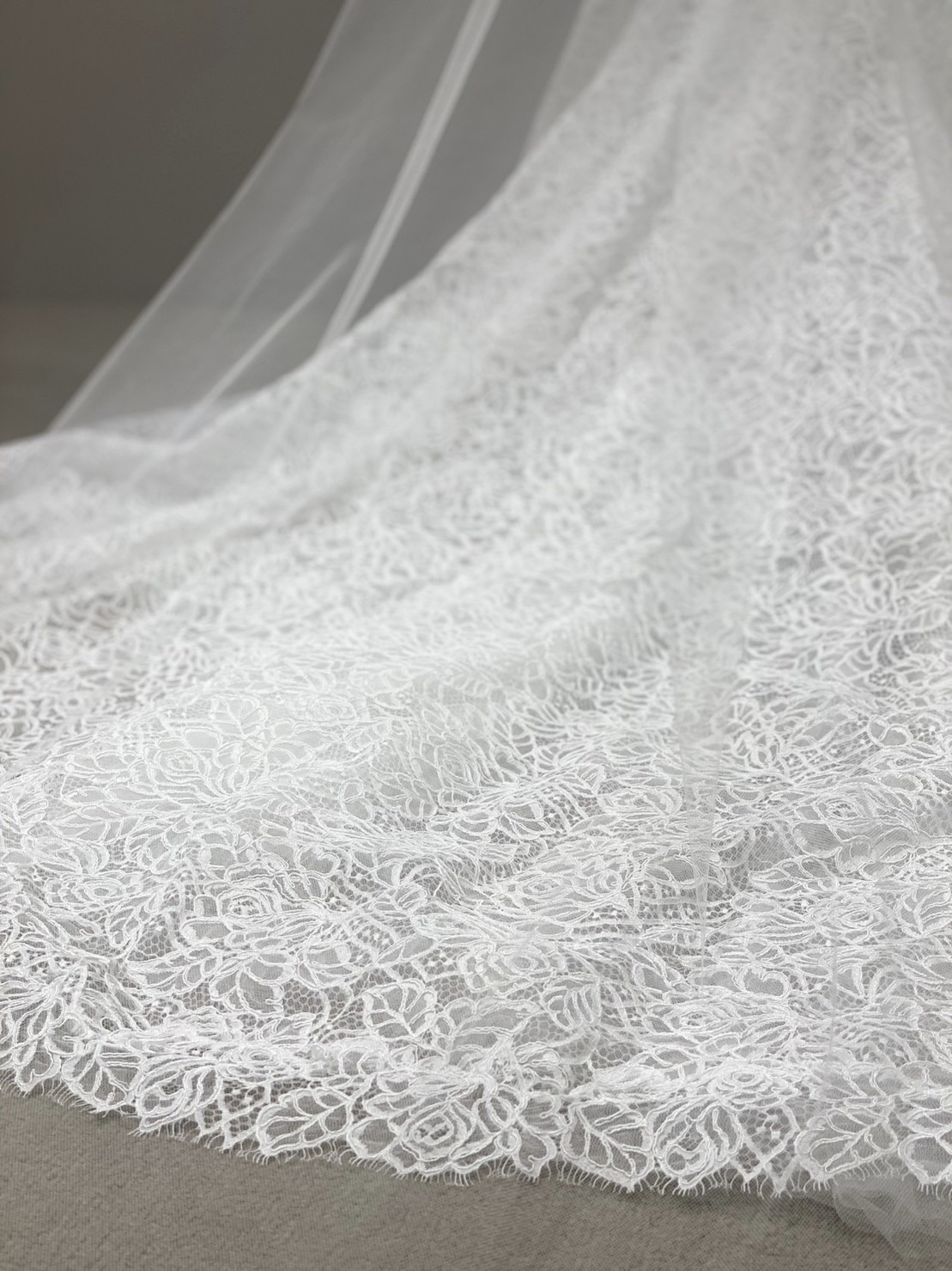 総レースの長いトレーンが美しくひろがり、チャペルのバージンロードに映えるウエディングドレス