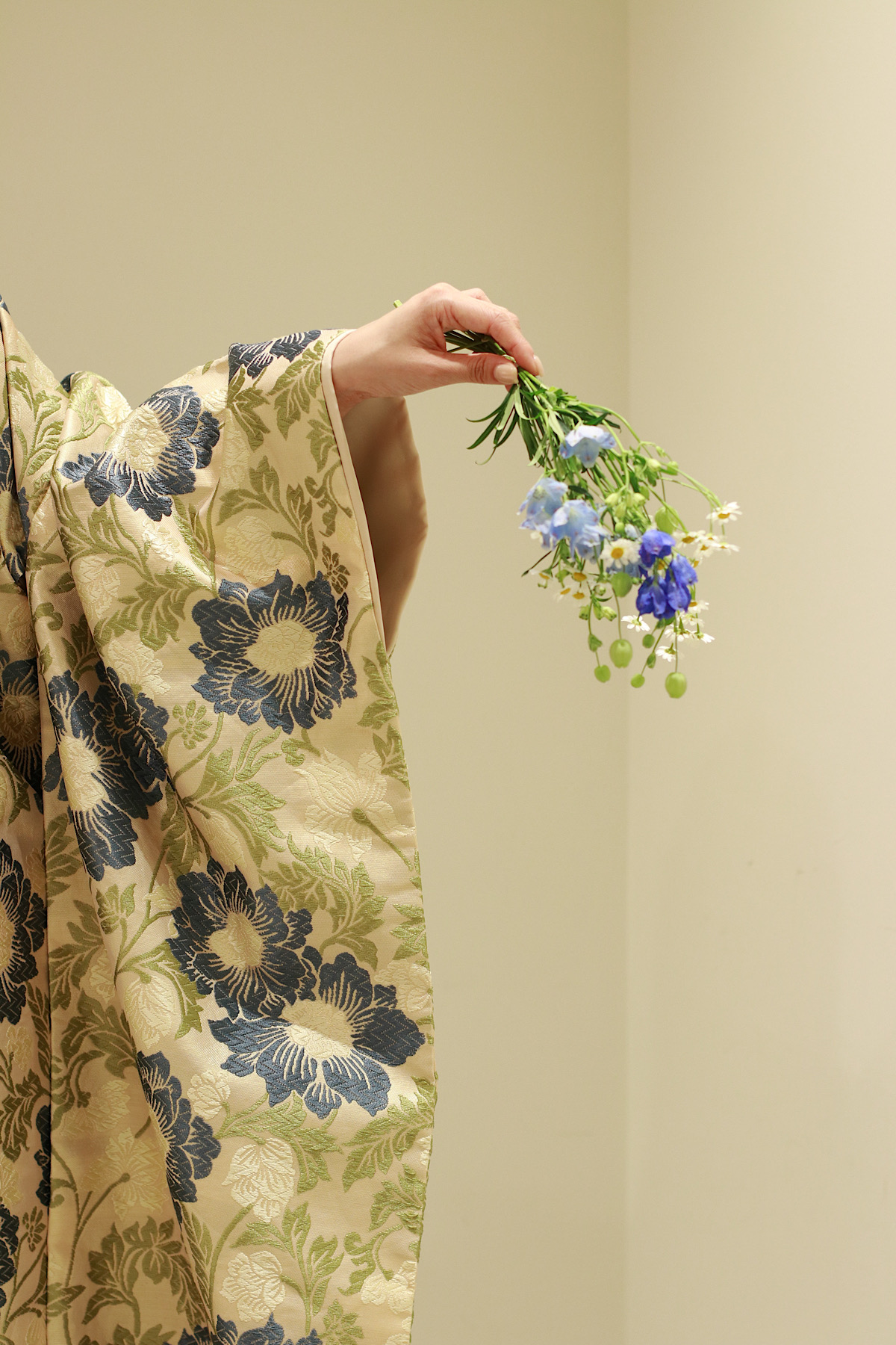 トリートドレッシングでお取り扱いしている色打掛、新作の色打掛を纏う花嫁の手元には色打掛の色味からひろった若草色や水色、深い青色の草花を合わせ可憐な印象に昇華します