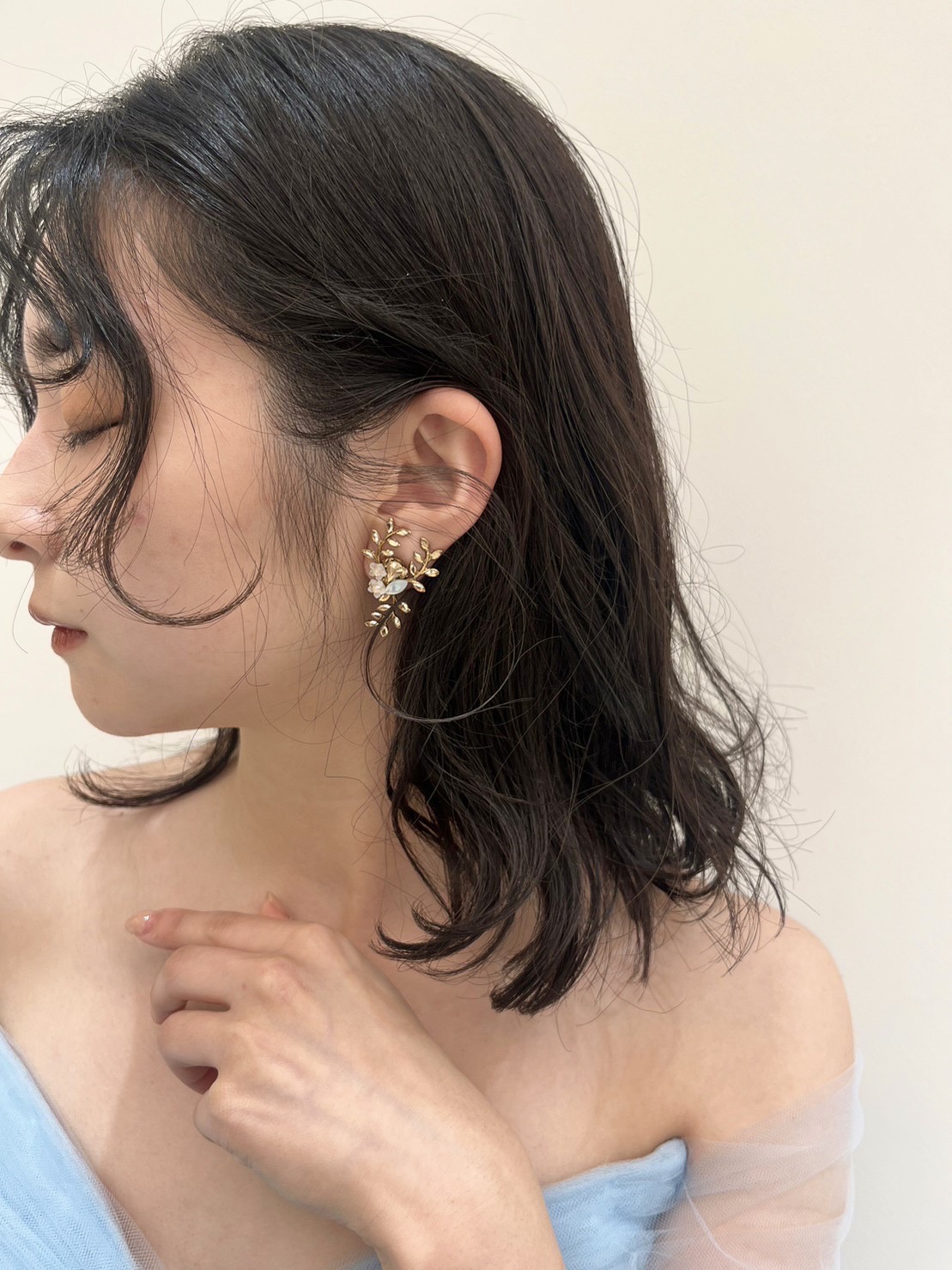 鮮やかなブルーのカラードレスに合わせるゆるふわなヘアスタイルにナチュラル感あふれるゴールドのリーフモチーフのイヤリングを合わせた特別感あるコーディネートをご提案いたします。