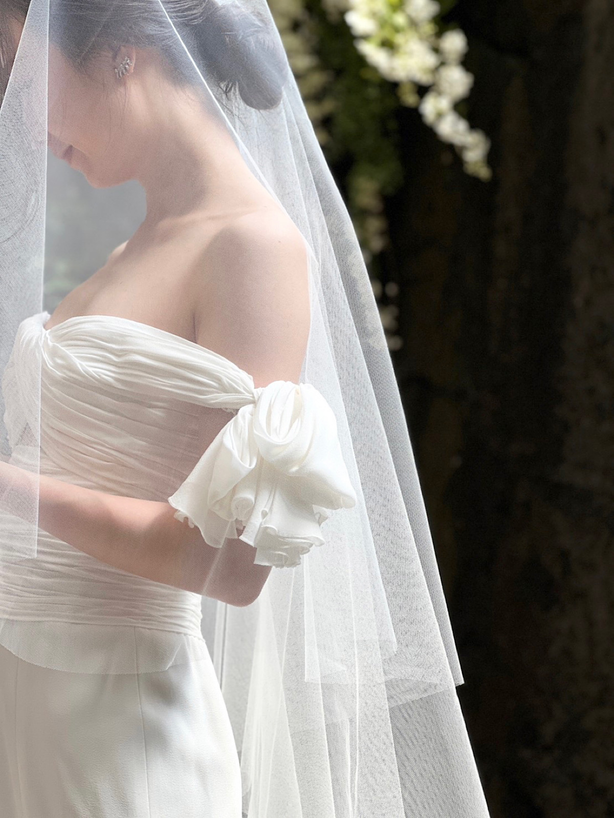 神聖なキリスト式にもおすすめの透明感のあるベールを合わせたジャンバティスタ ヴァリのオフショルダーのウェディングドレス