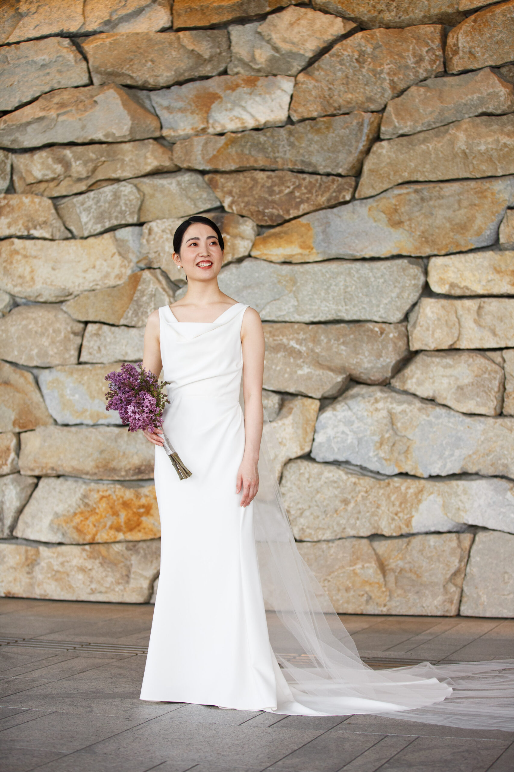 NY発のモダンでタイムレスなデザインを叶えるアムサーラのウェディングドレス。クレープ生地が生み出す柔らかなドレープは花嫁のシルエットを引き立てます。