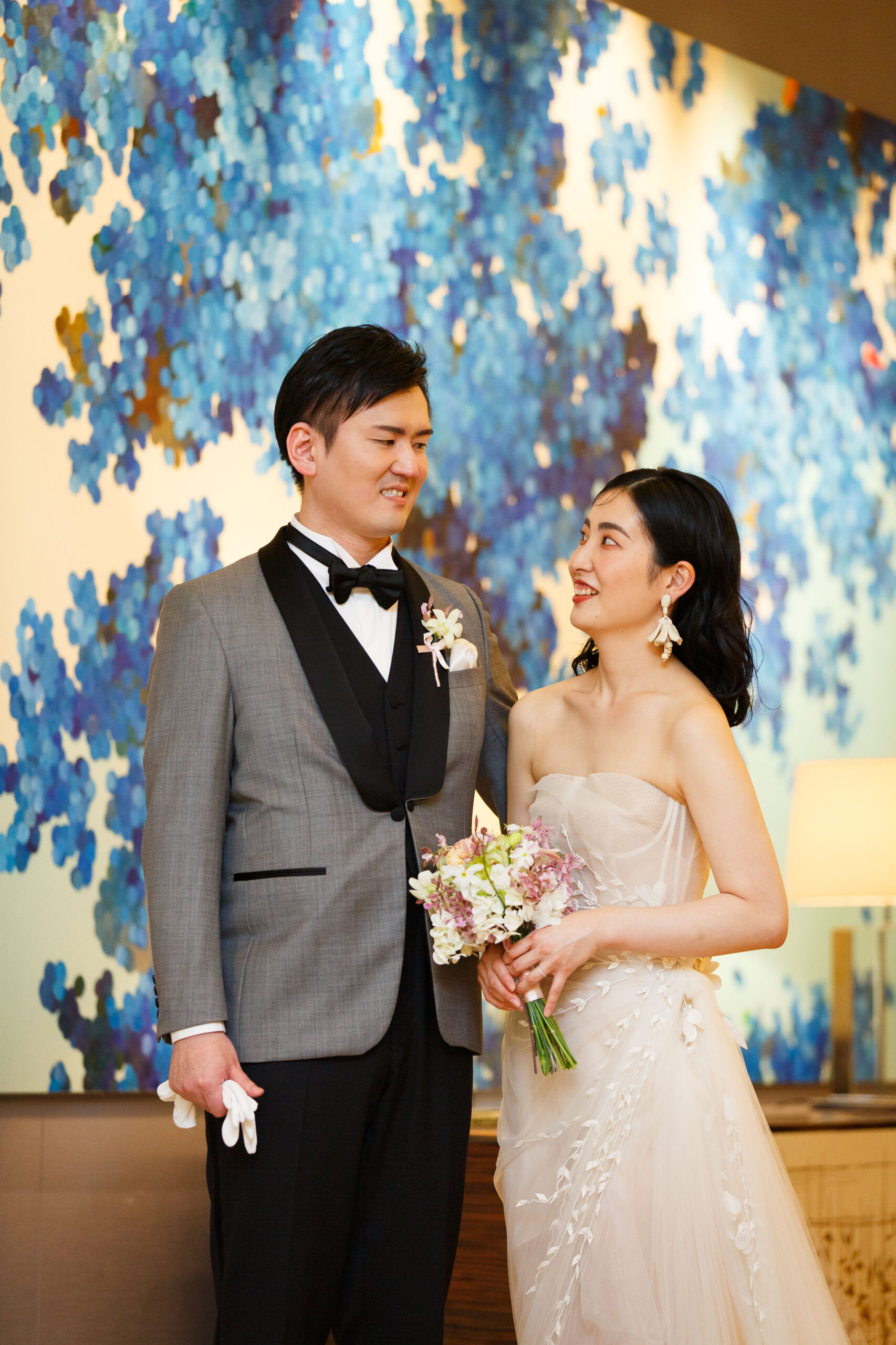 パレスホテル東京での結婚式のご紹介。 ザトリートドレッシングアディション店でお取り扱いしている広瀬すずがドラマで着用したオスカー デ ラ レンタのウェディングドレスをお色直しで纏うご新婦様とグレーのタキシードでエスコートをするご新郎様。