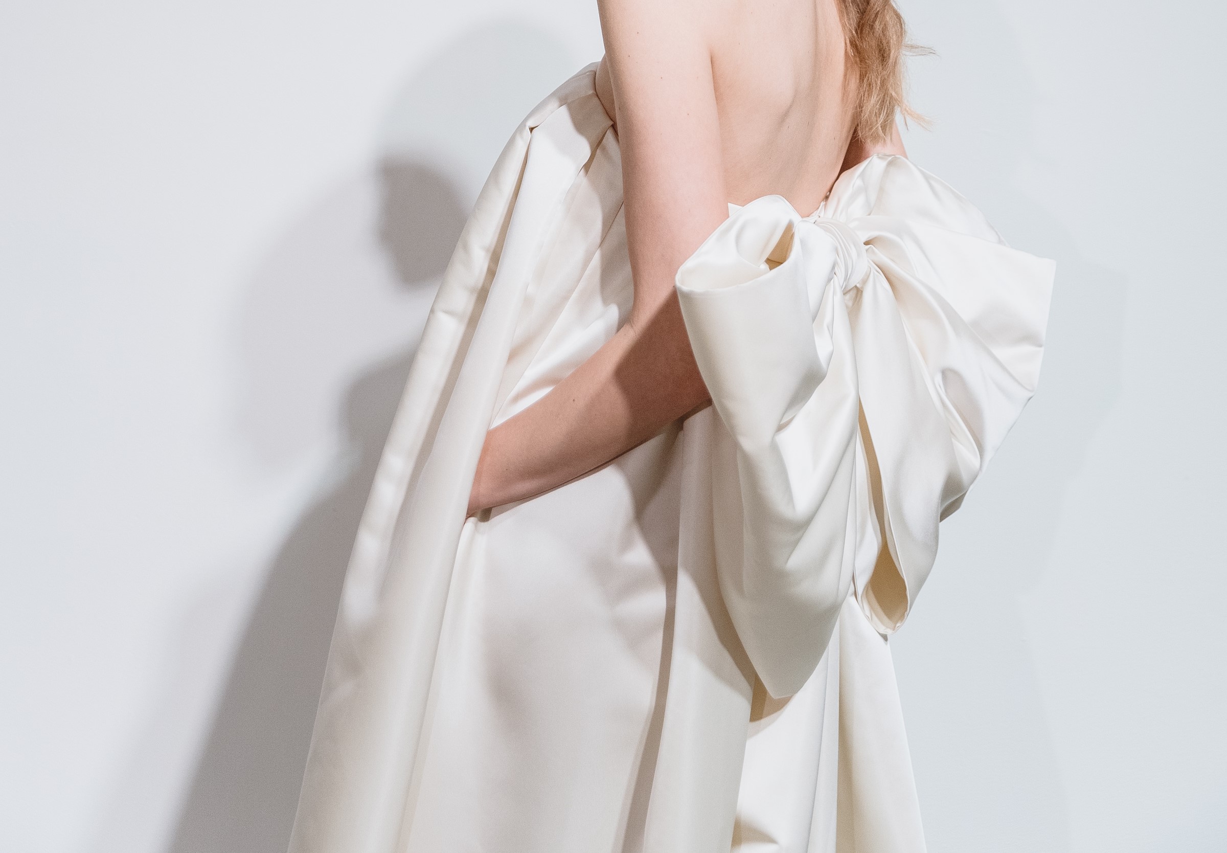 ウェディングドレスの最新トレンドを2024春夏のコレクションよりお届け、背中のビッグリボンが目を惹く新しいデザインです