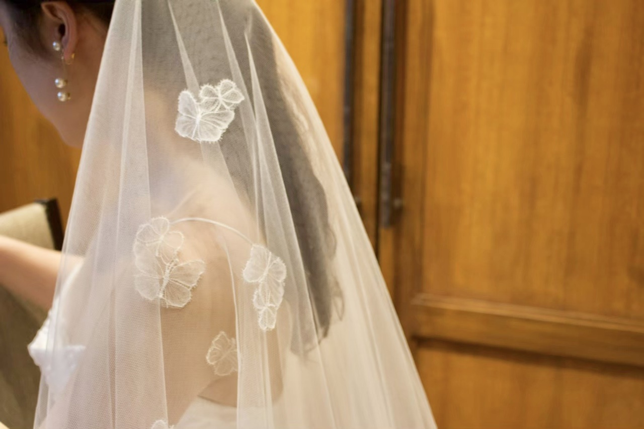 肩周りにあしらわれたフラワーモチーフは、シンプルなドレスをエレガントで華やかな印象に仕上げてくれます