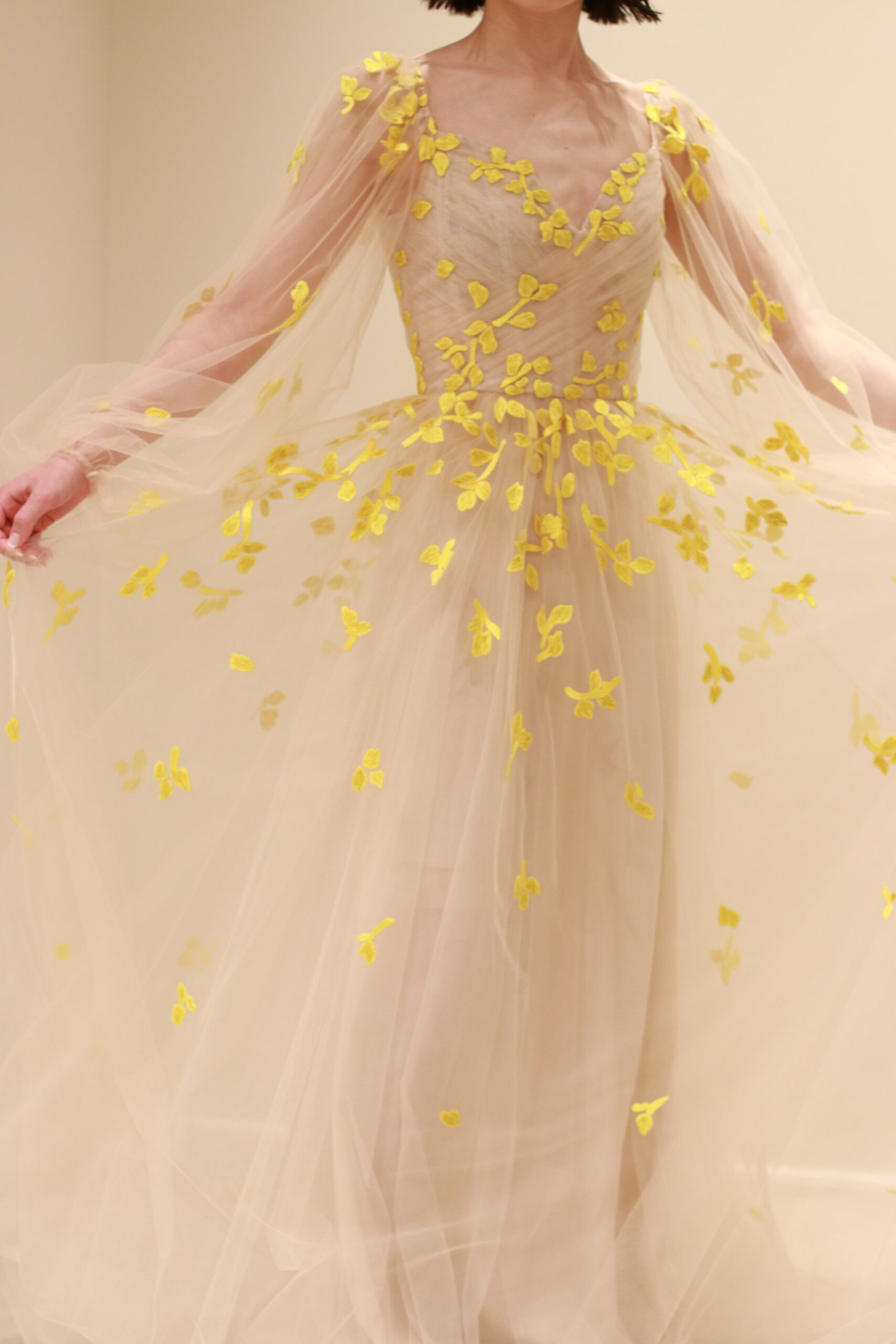 ザトリートドレッシングに入荷したモニークルイリエの新作カラードレスはベージュの柔らかなチュールの上に、イエローの刺繍で花びらの施されたデザインです。