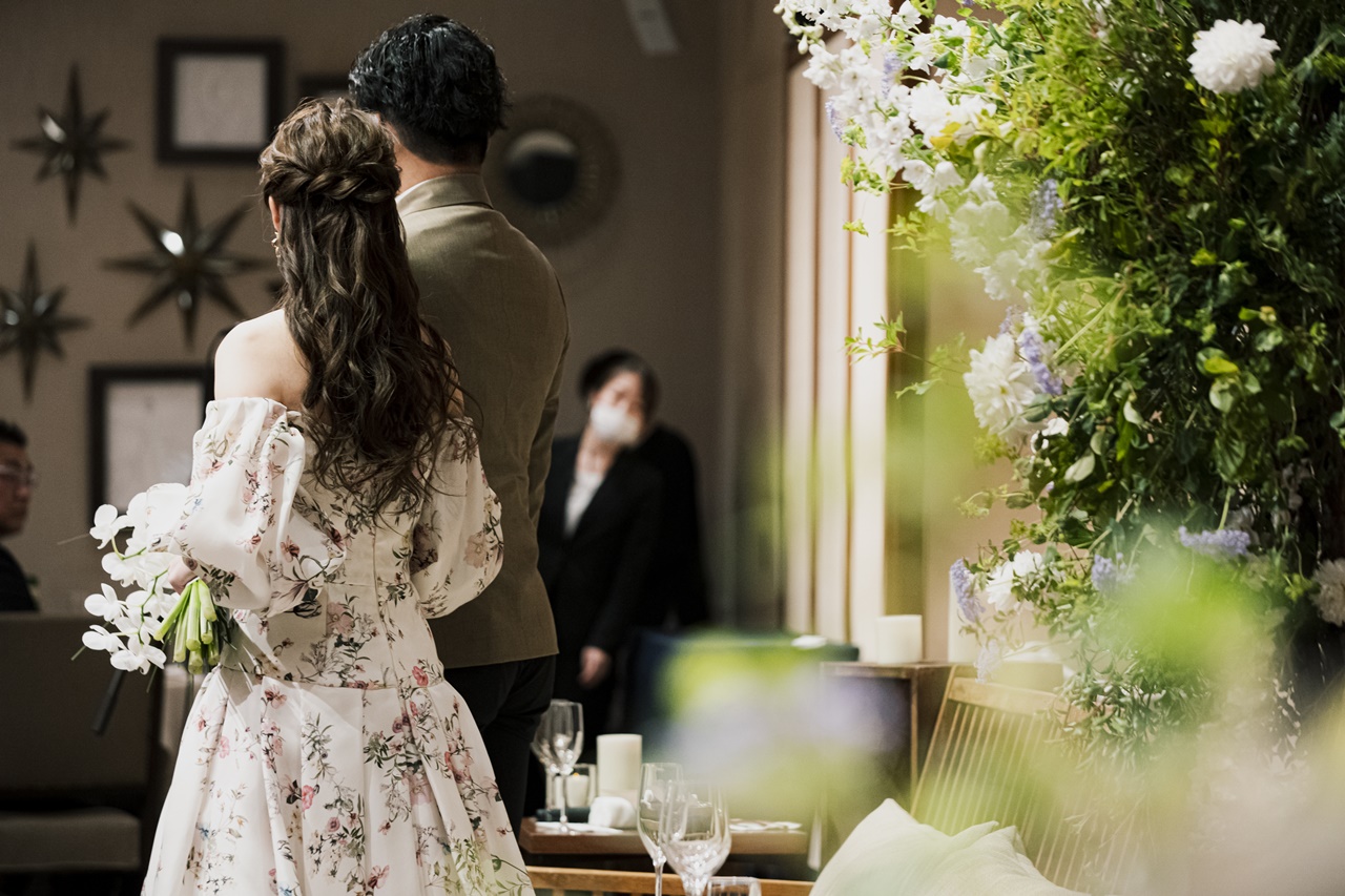 披露宴入場はMonique Lhuillierのパフスリーブとフラワープリントがなんともロマンティックなカラードレスです