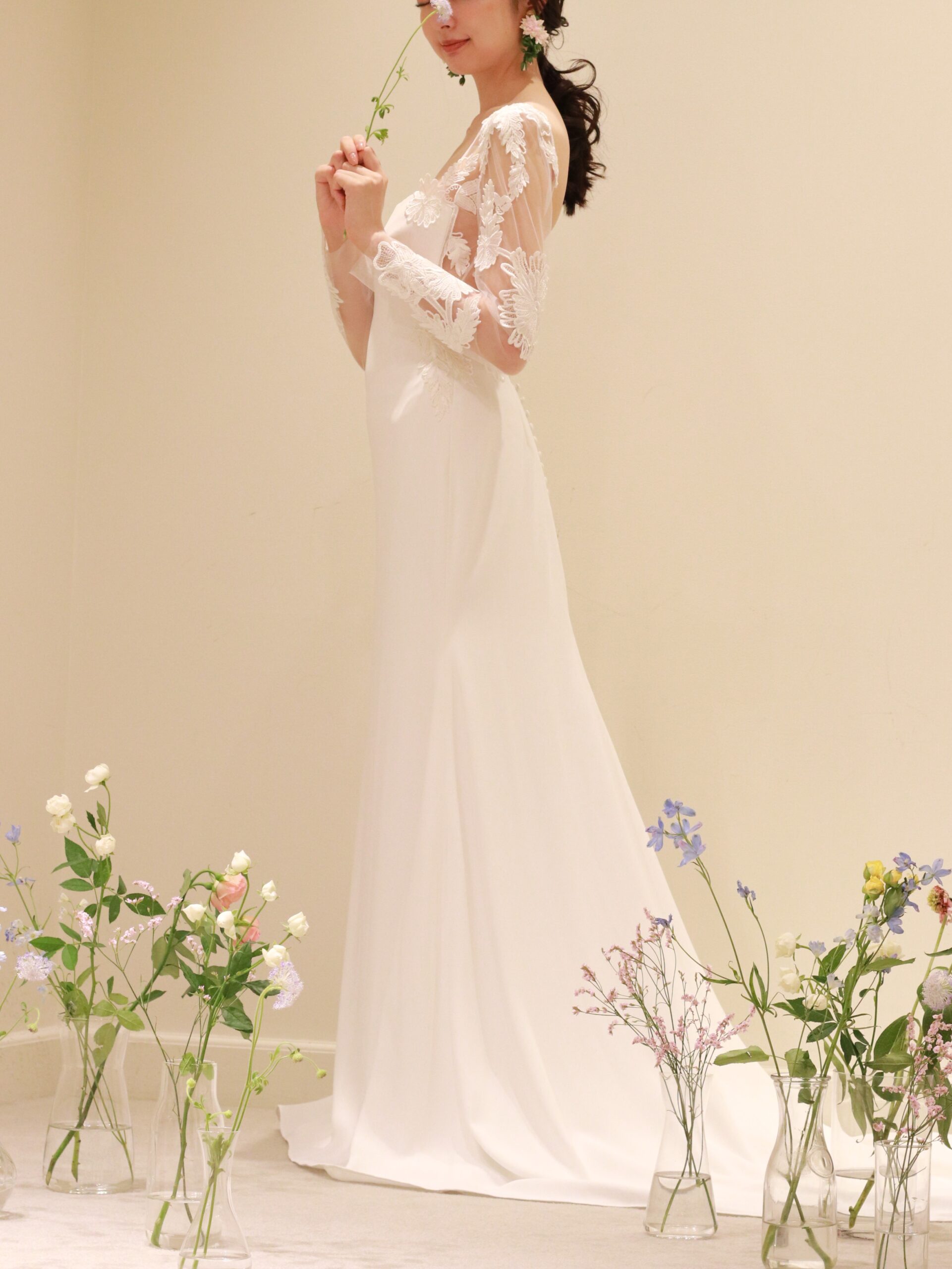 結婚式でお召いただきたいおすすめの新作ウェディングドレス、クラシックなウェディングドレスにアットホームなローポニーテールを合わせてリラックス感のあるコーディネートをおすすめします